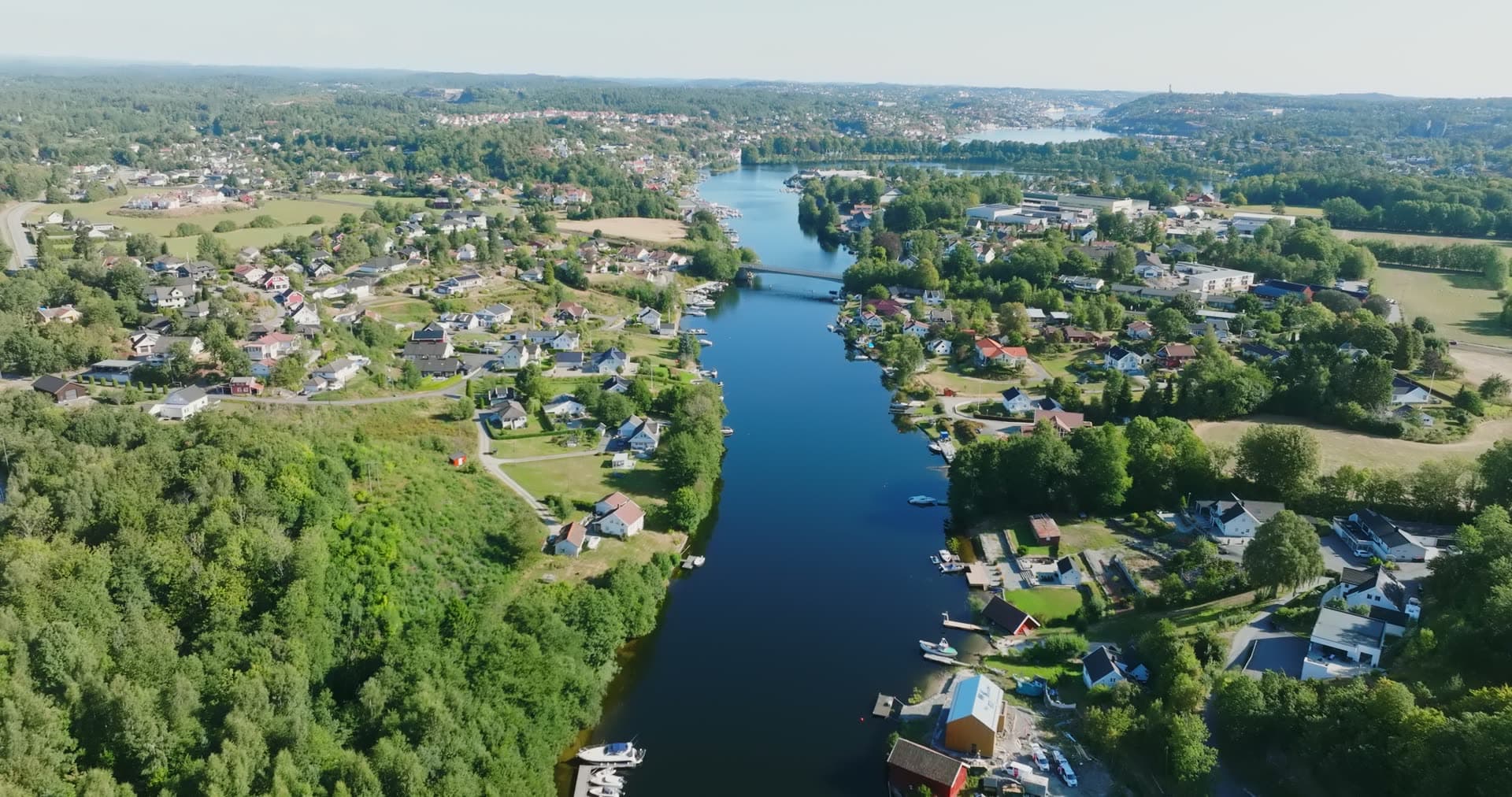 River with boathouses and road bridge, Bomsholmen, Norway