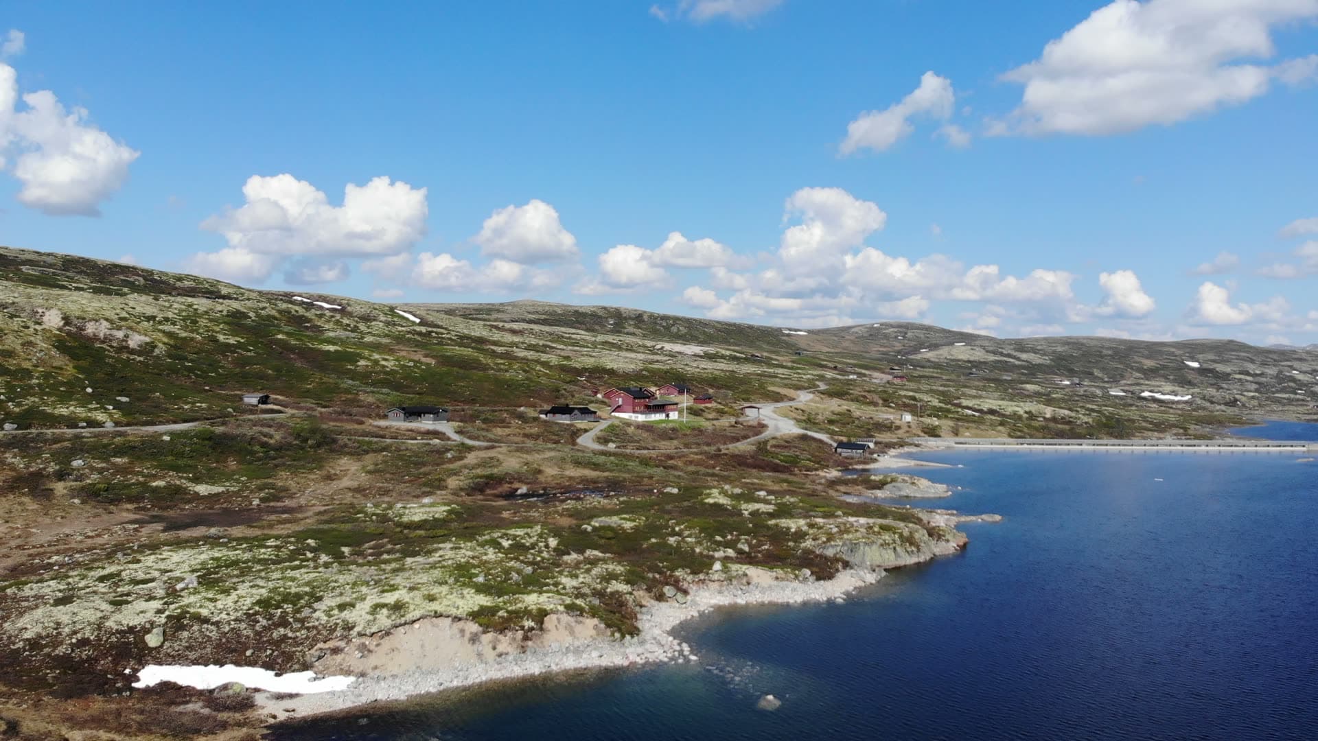 Red cabins above lake shore on bare plateau, Gaustatoppen, Norway
