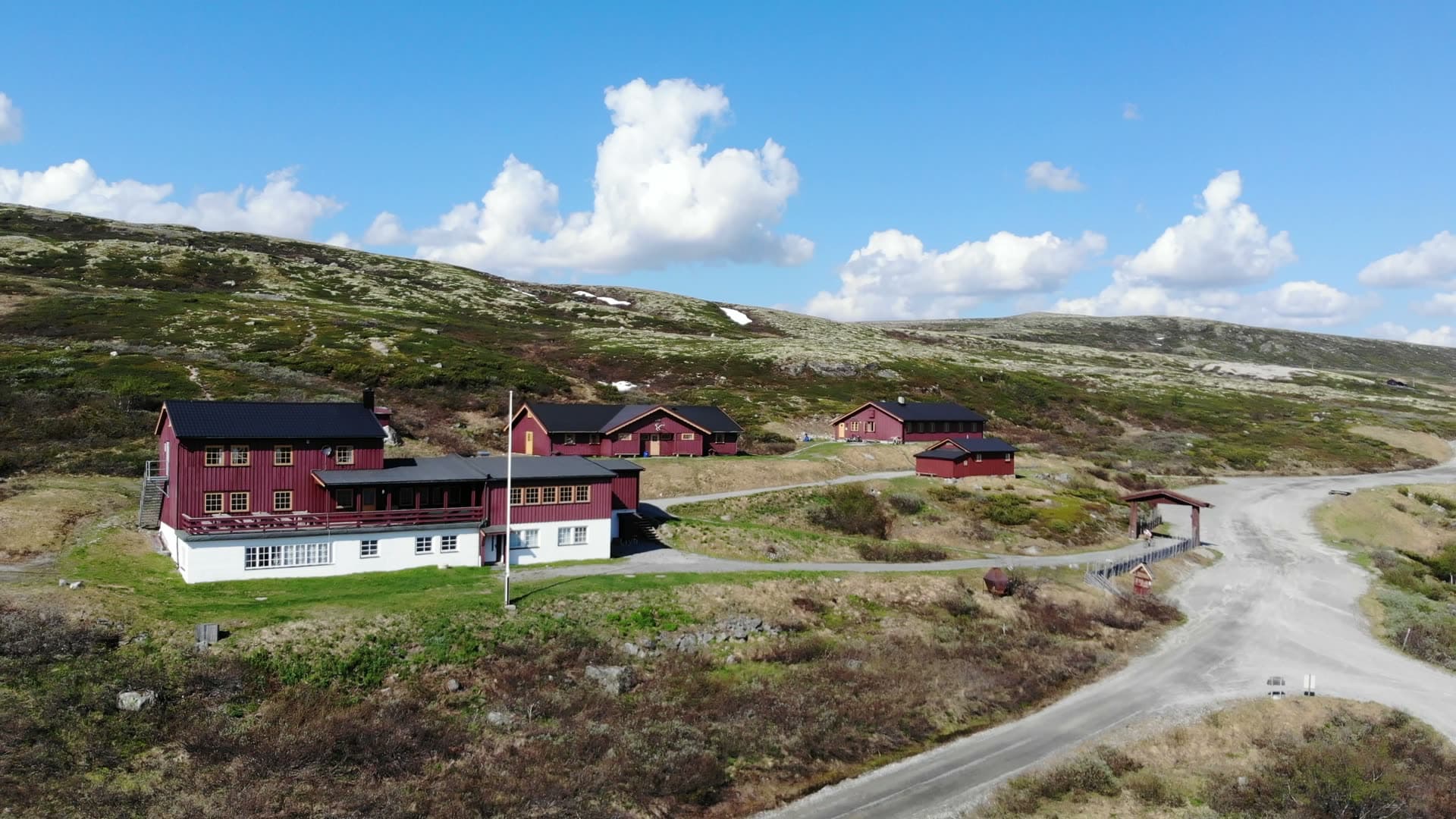 Red mountain lodge and cabins by gravel road, Gaustatoppen, Norway