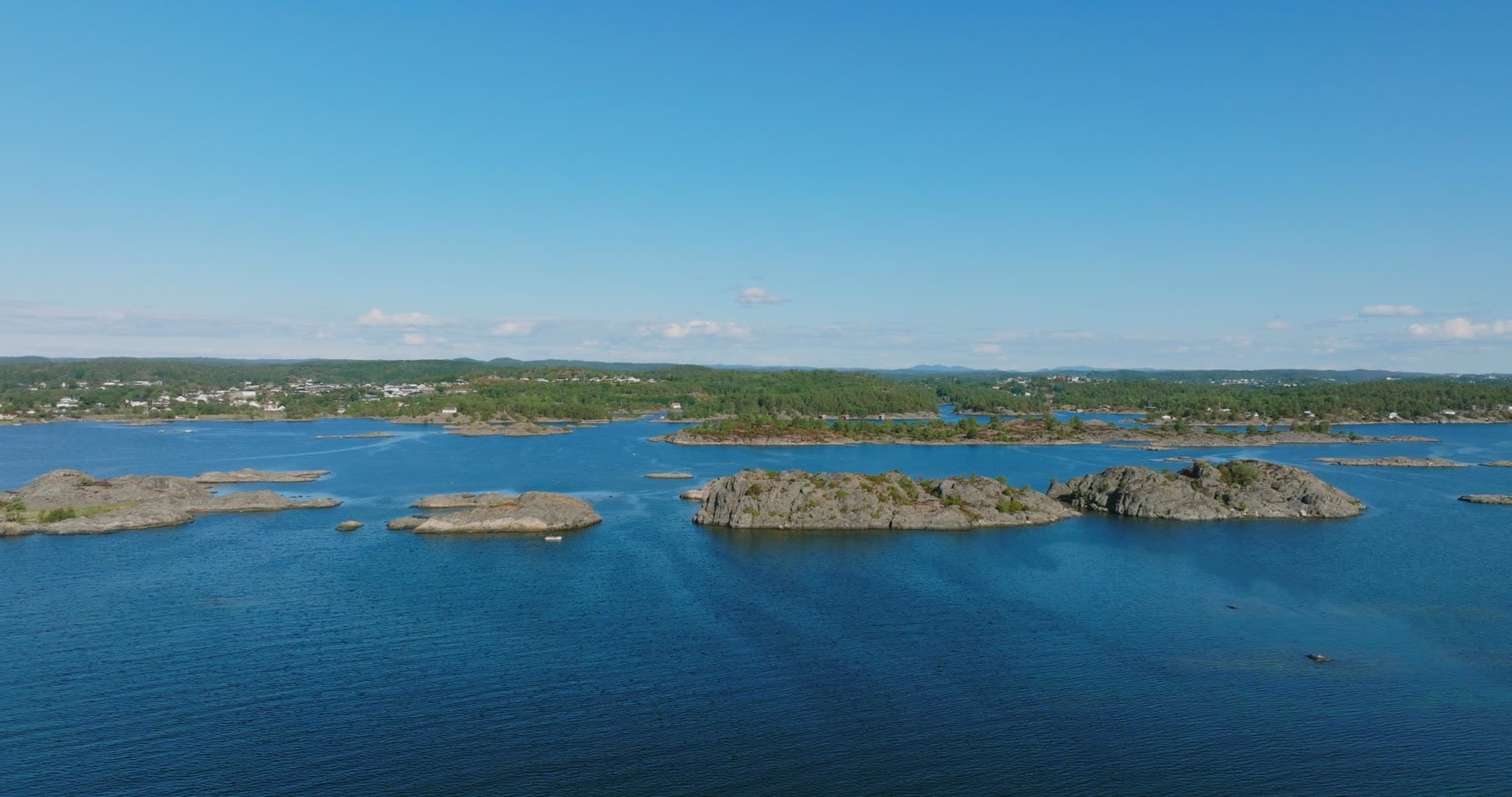 Bare rocky skerries and boat wake, Hasseltangen, Norway