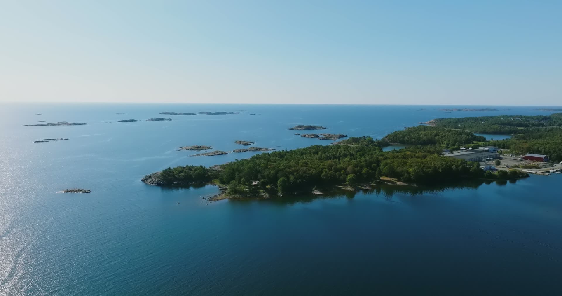 Wooded headland, bare skerries and sheds, Hasseltangen, Norway