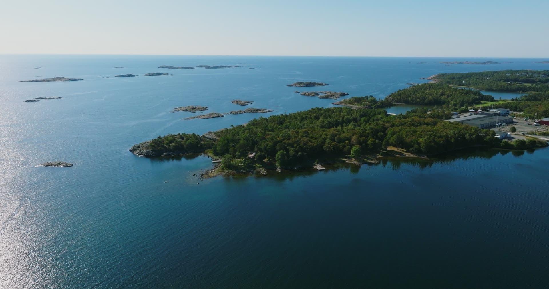 Wooded headland, bare skerries offshore, Hasseltangen, Norway