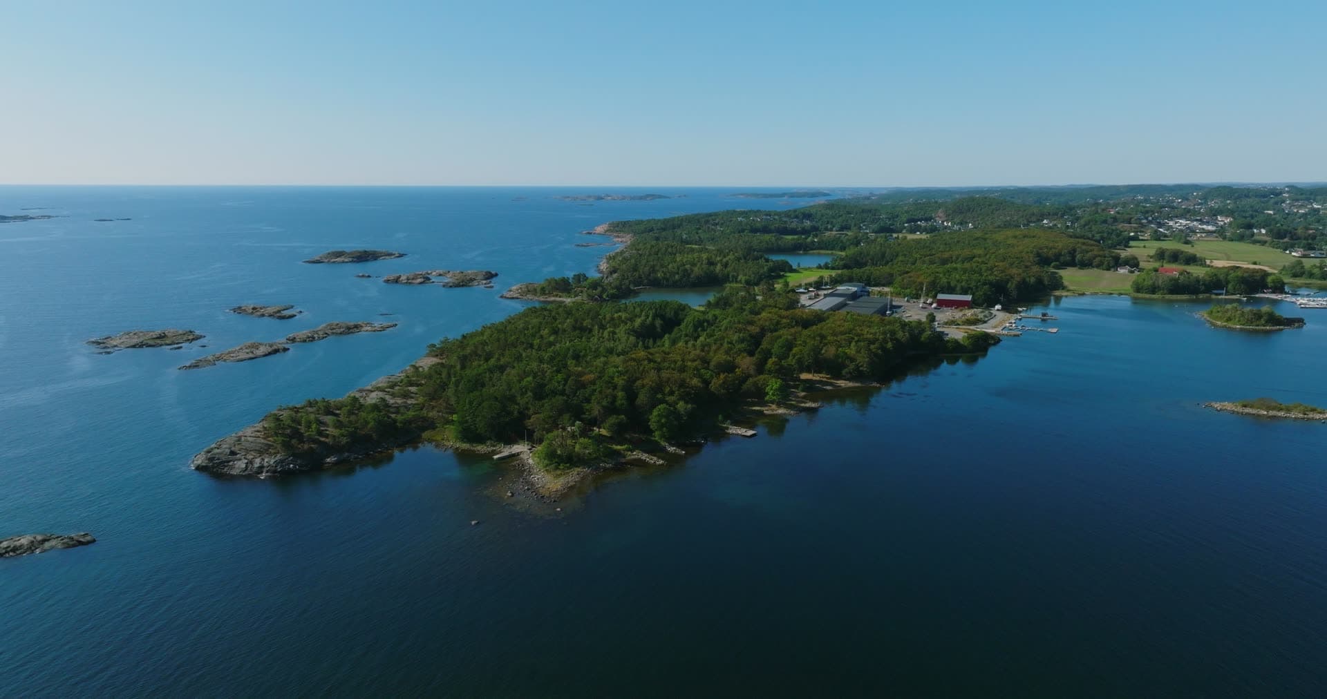 Wooded headland, red barn and marina behind, Hasseltangen, Norway