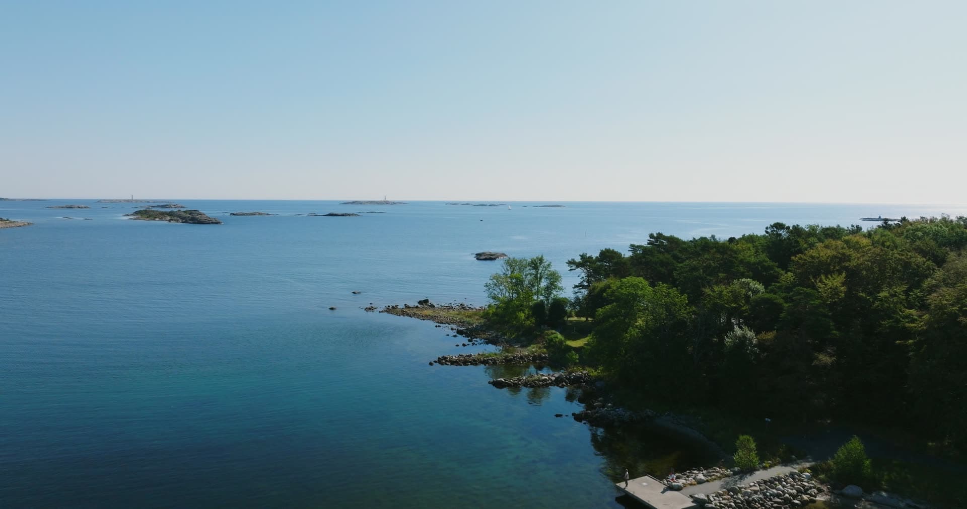 Wooded headland with small jetty and skerries, Hasseltangen, Norway