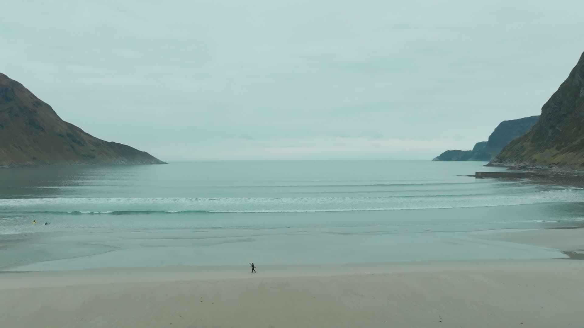 Lone walker on wide sand beach at low tide, Hoddevik, Norway