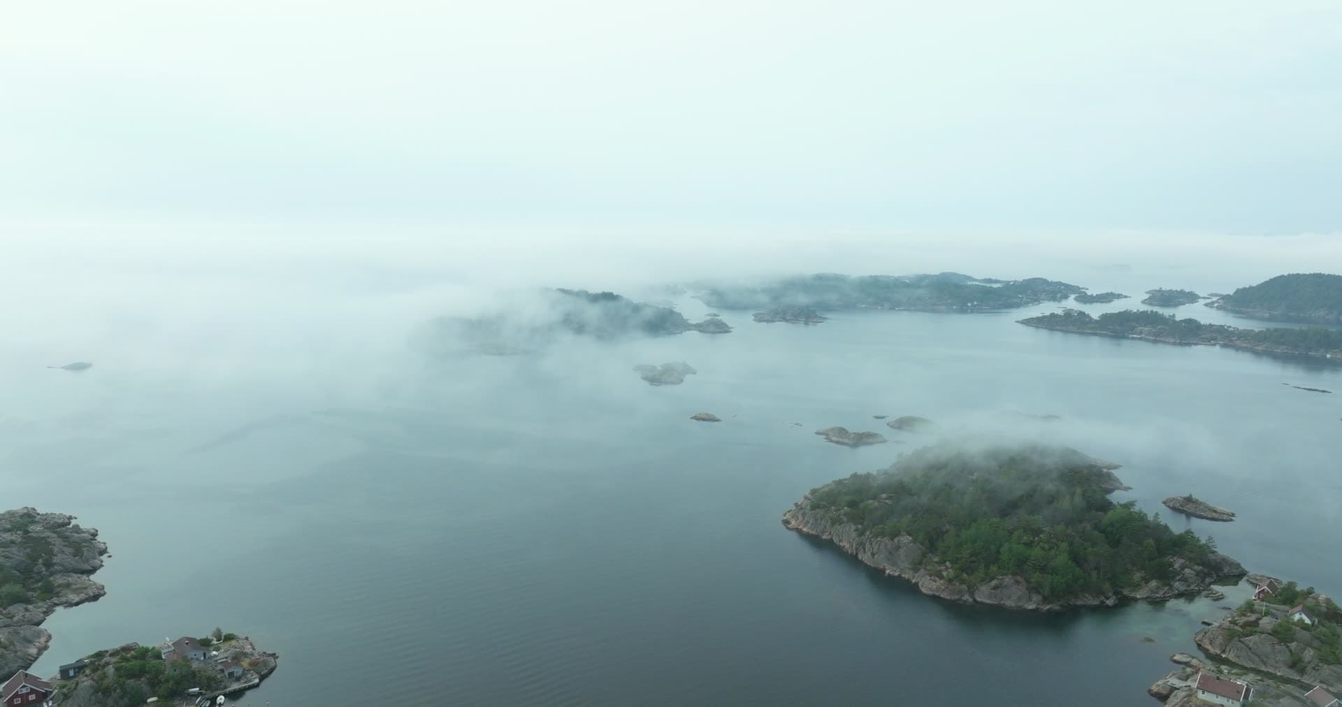 Fog drifting over wooded skerries, Høllen, Norway