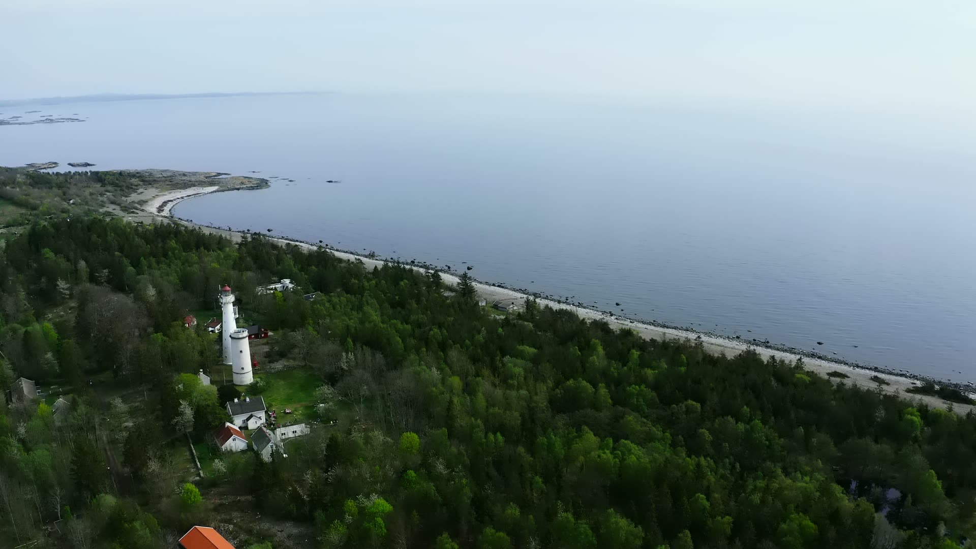 Two white lighthouse towers above pebble beach, Jomfruland, Norway