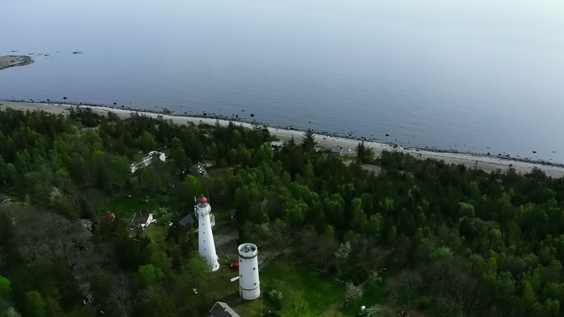 Two white lighthouse towers above pebble beach, Jomfruland, Norway