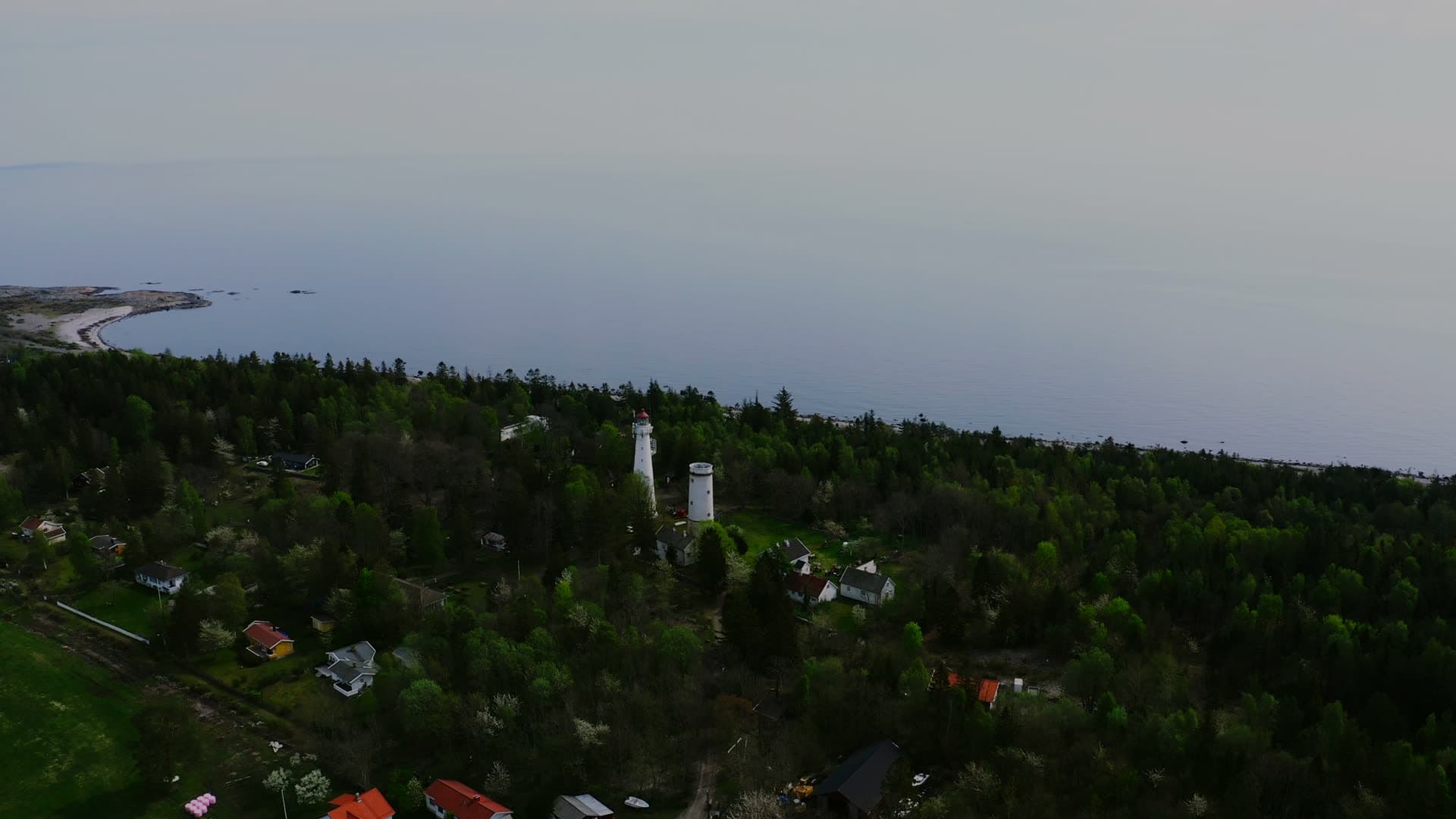 Two white lighthouse towers above pine forest, Jomfruland, Norway