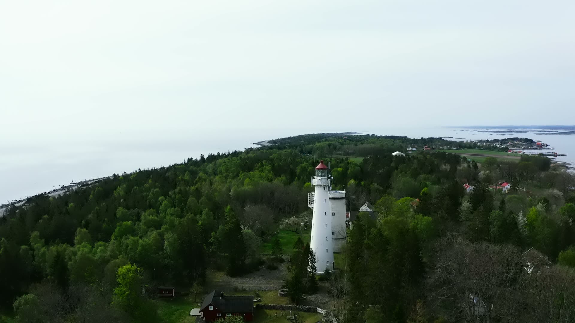 Two white lighthouse towers above forest, Jomfruland, Norway