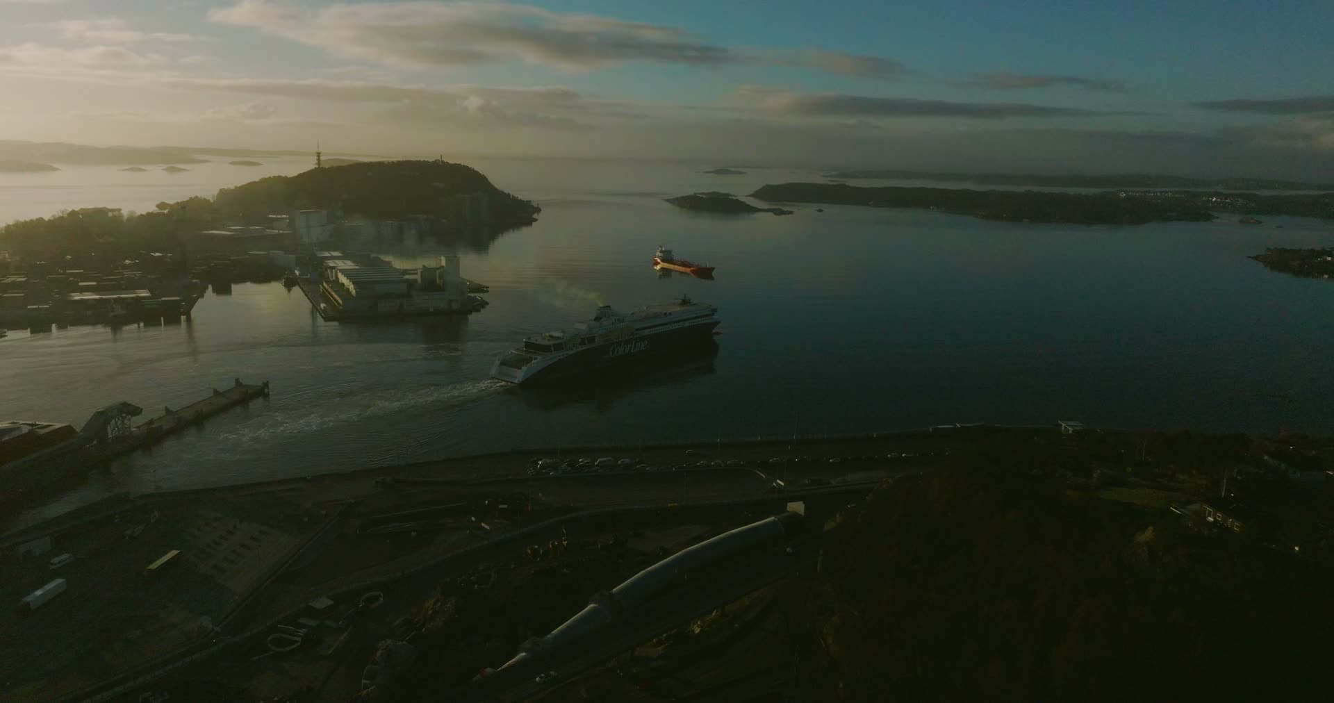 Car ferry leaving harbour at sunrise, Kristiansand, Norway