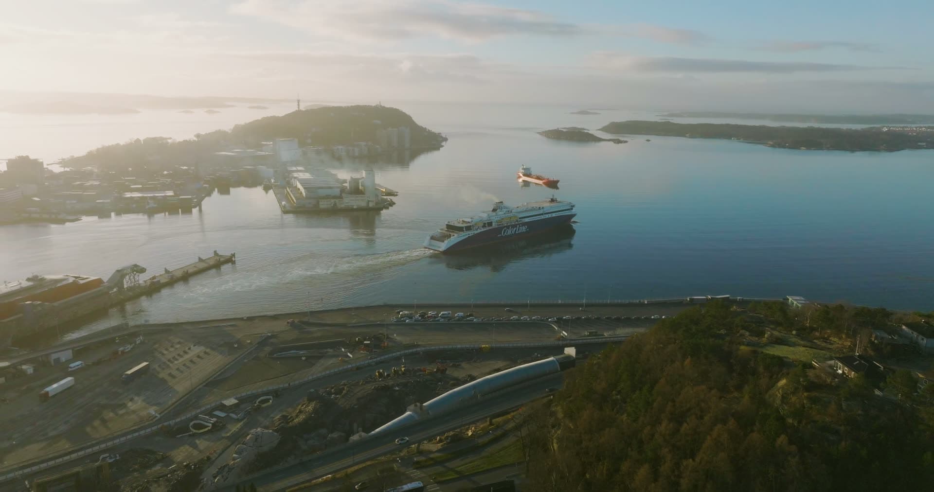 Ferry crossing the sound past the coastal road, Kristiansand, Norway