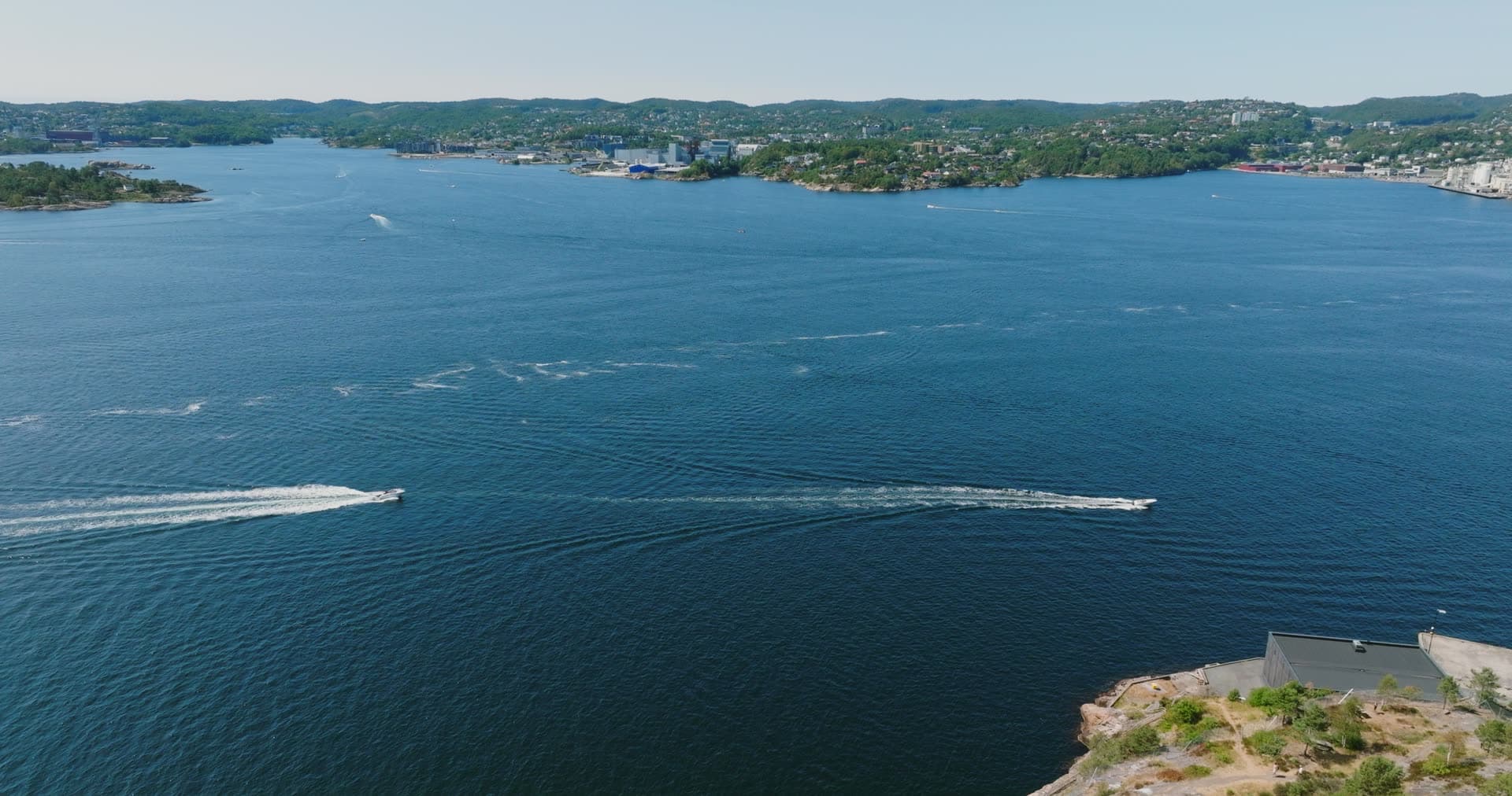 Speedboats leaving wakes across the fjord, Kristiansand, Norway