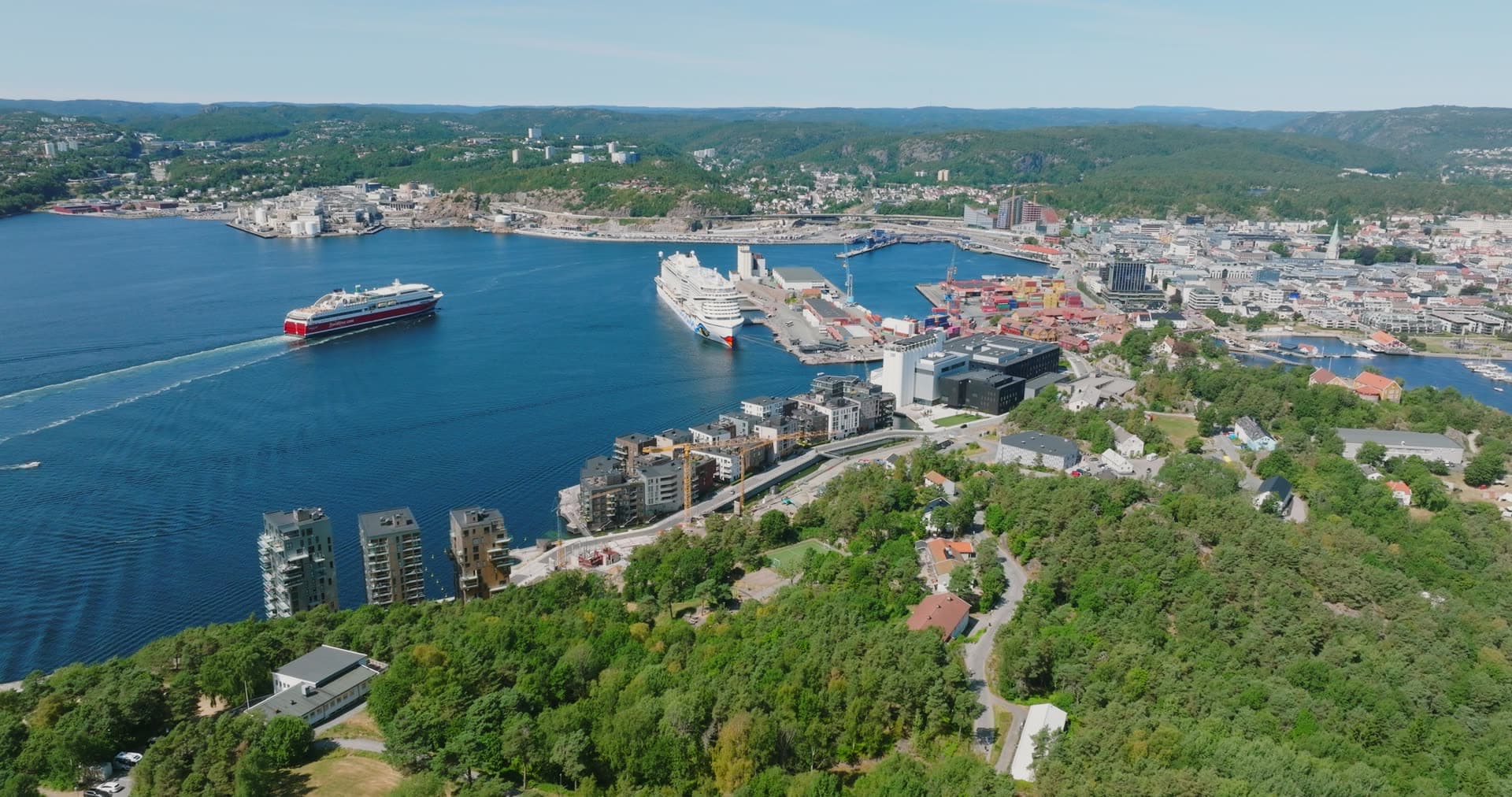 Ferry departing past the moored cruise ship, Kristiansand, Norway
