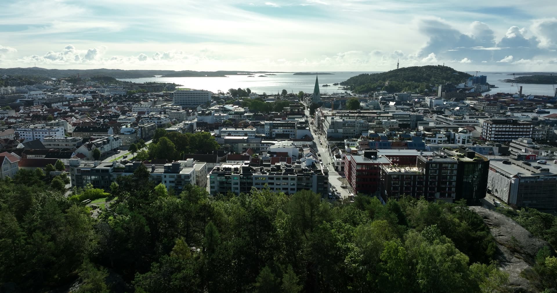 Wooded ridge over city grid and church spire, Kristiansand, Norway