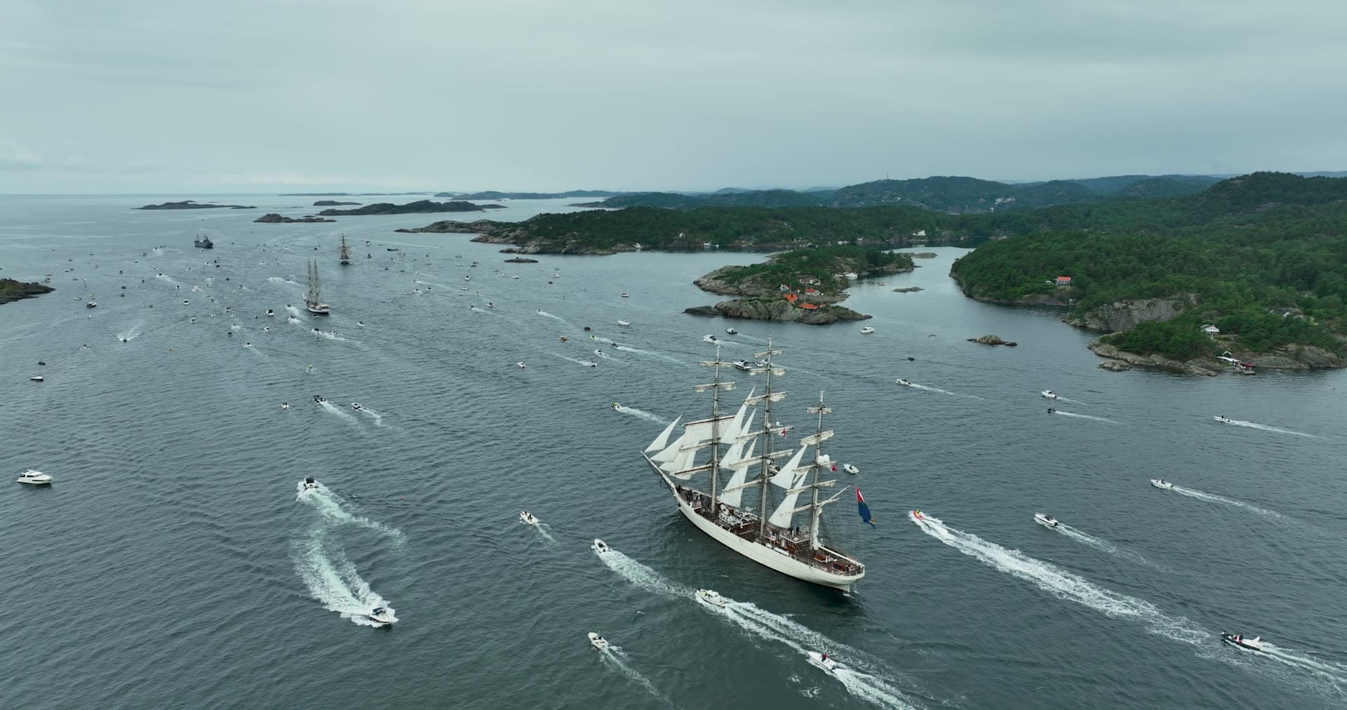 Tall ship escorted by motorboat flotilla, Kristiansand, Norway