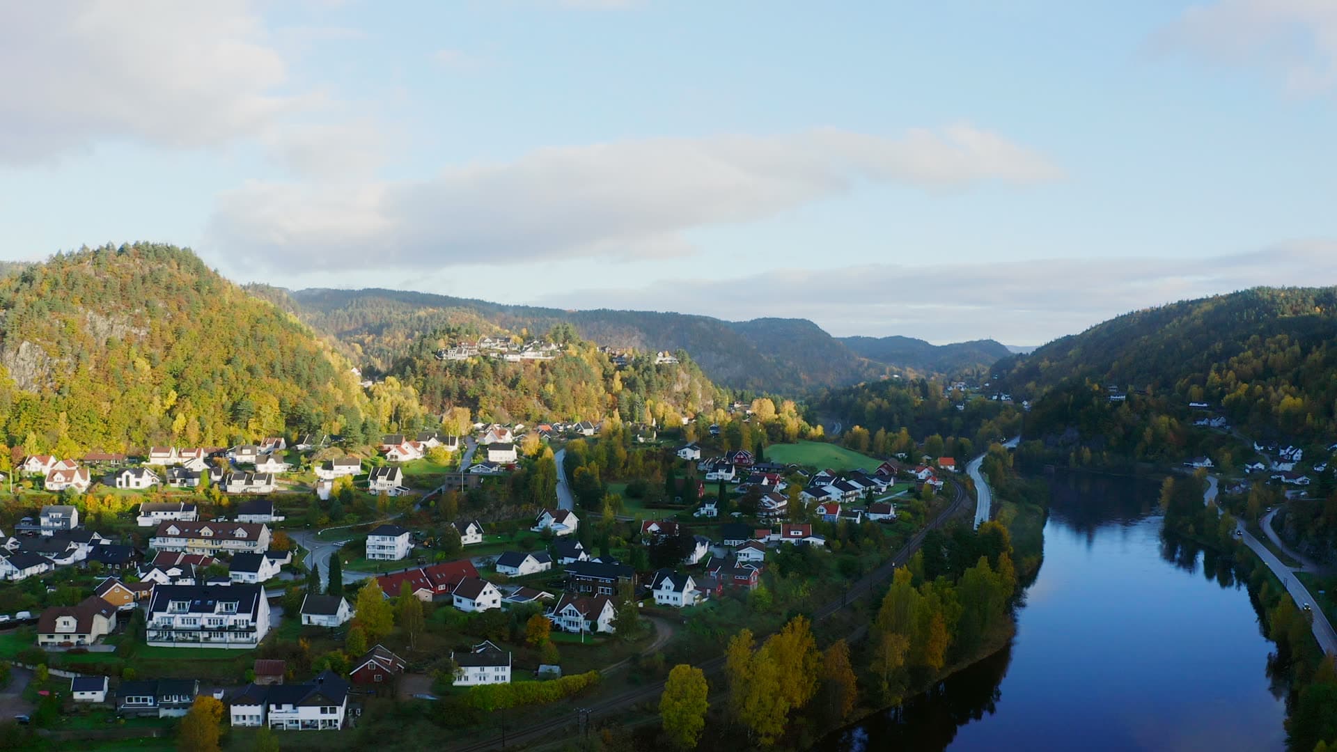White houses along still river below hills, Kvarstein, Norway