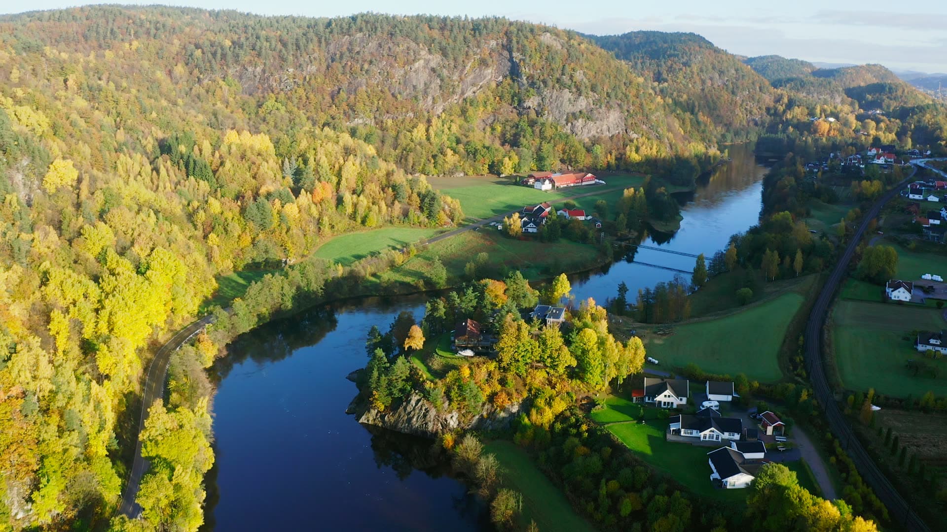 Suspension footbridge over autumn river, Kvarstein, Norway