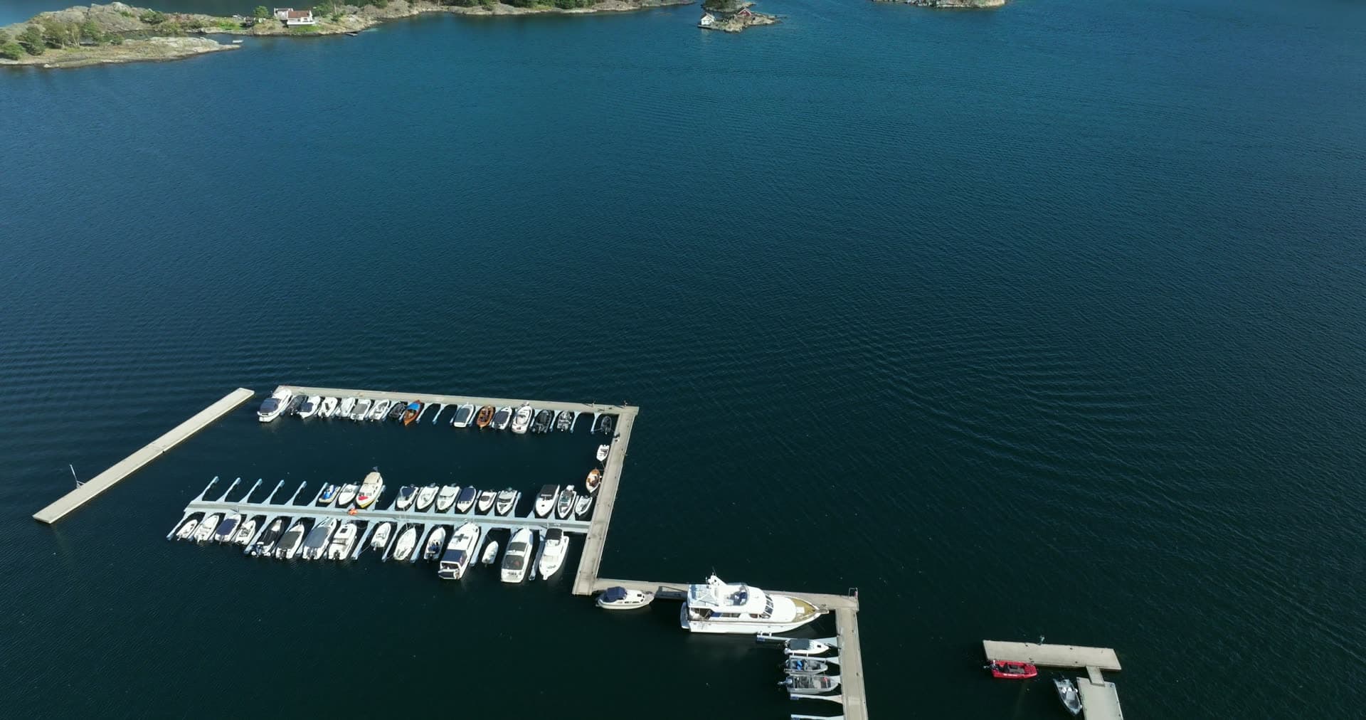 Marina pontoons with moored boats and skerries, Lillesand, Norway