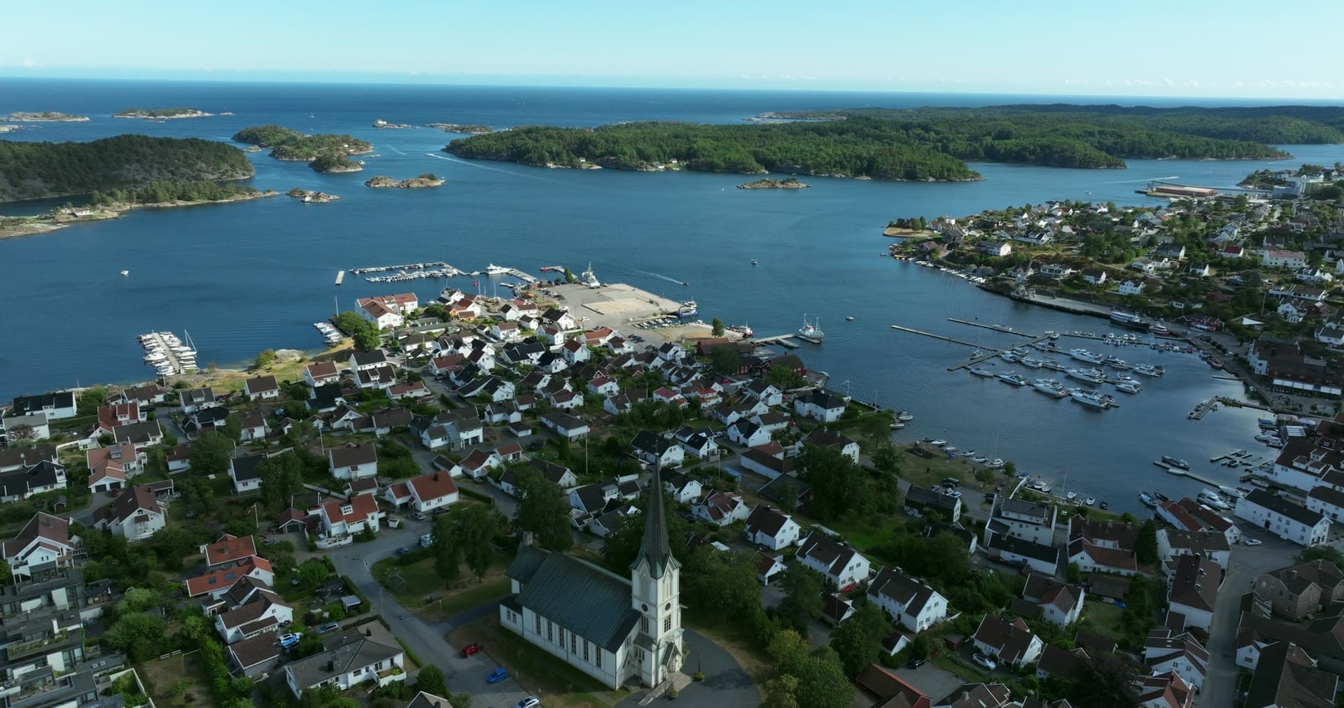 White church spire above town and marinas, Lillesand, Norway