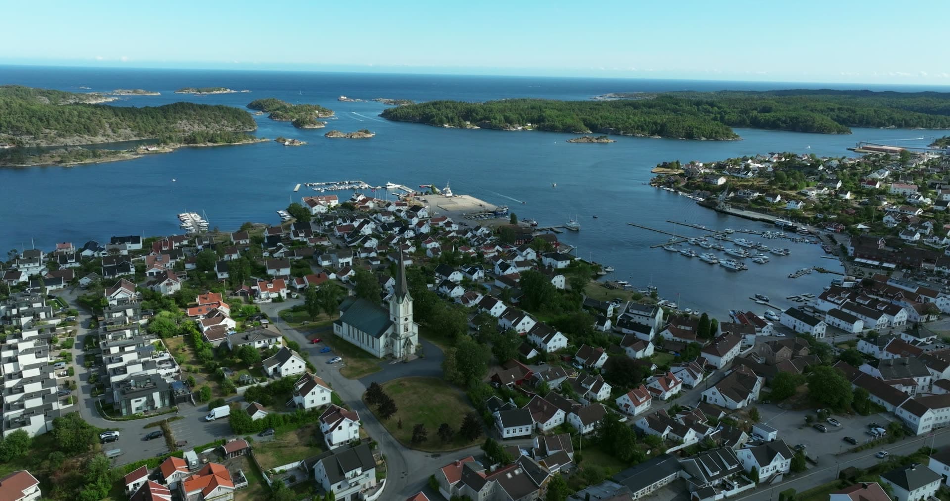 White church spire above town and marina, Lillesand, Norway