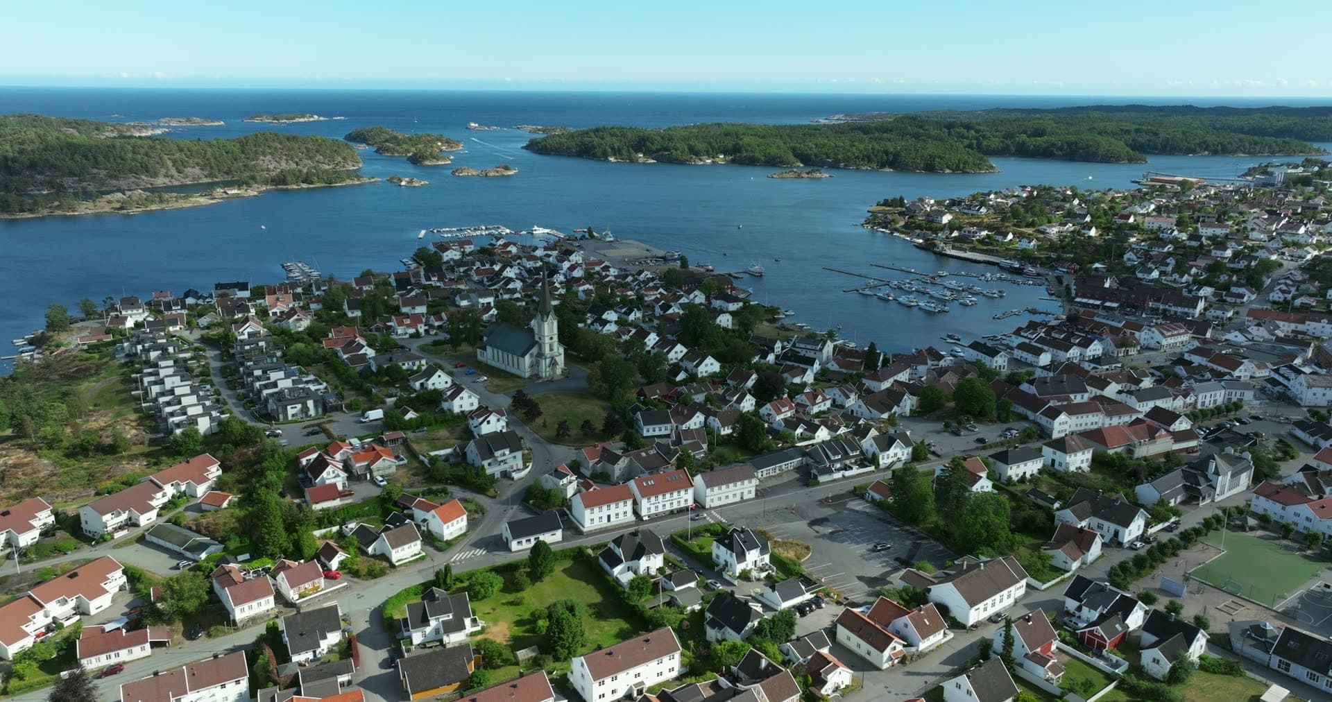 White church spire above town and marina, Lillesand, Norway