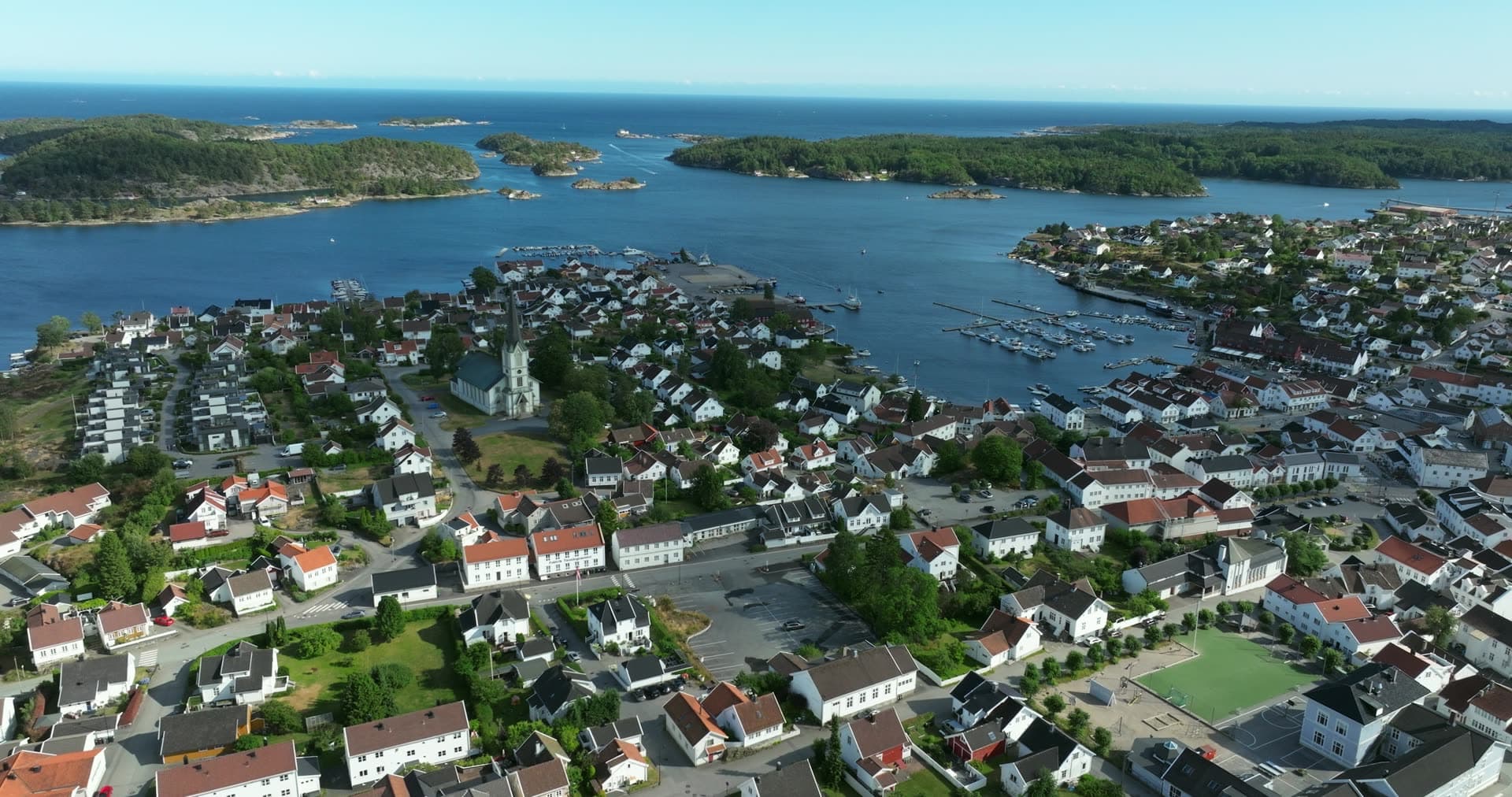 White church and marina between skerries, Lillesand, Norway