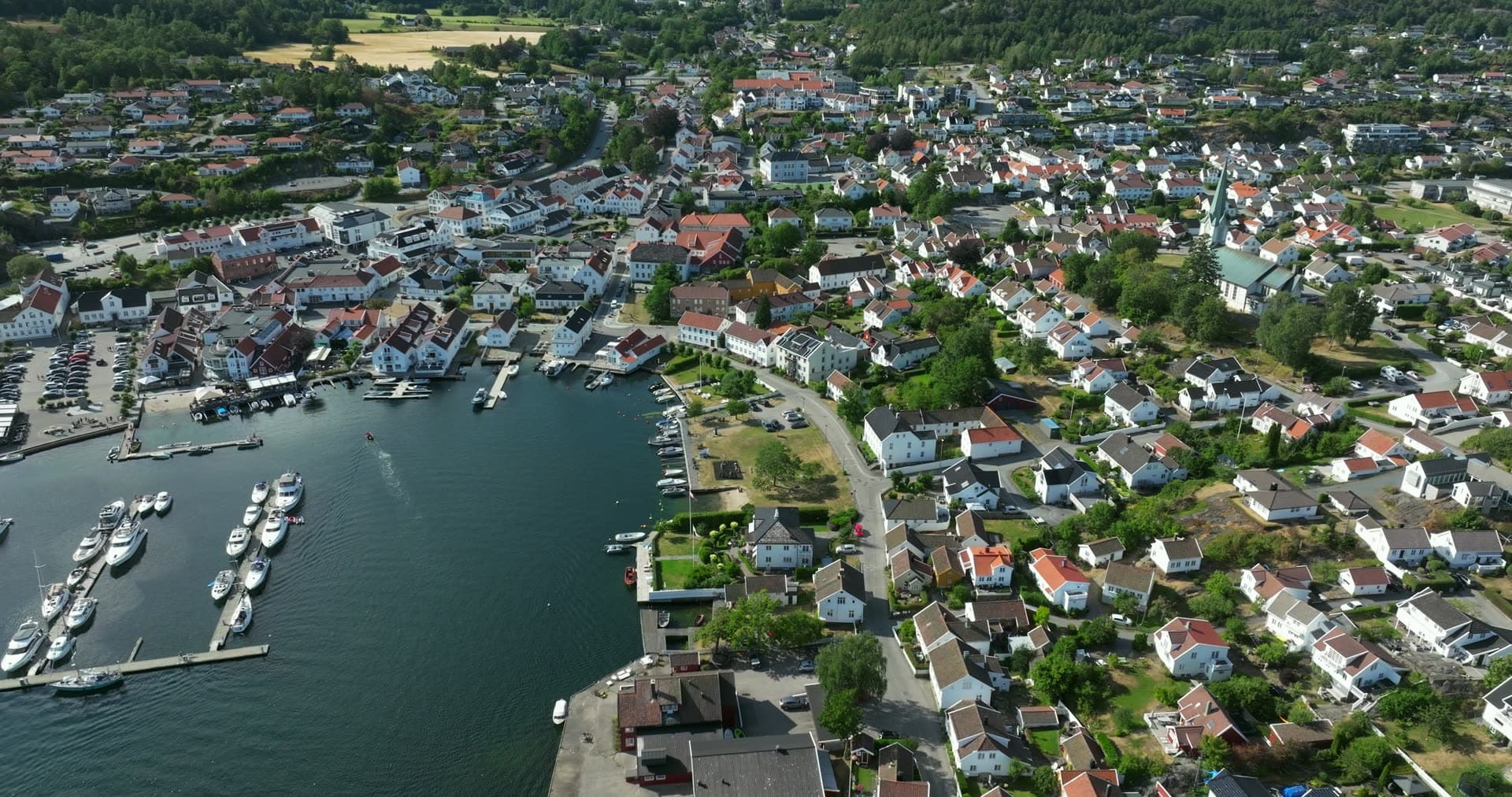 Marina pontoons and white church above town, Lillesand, Norway
