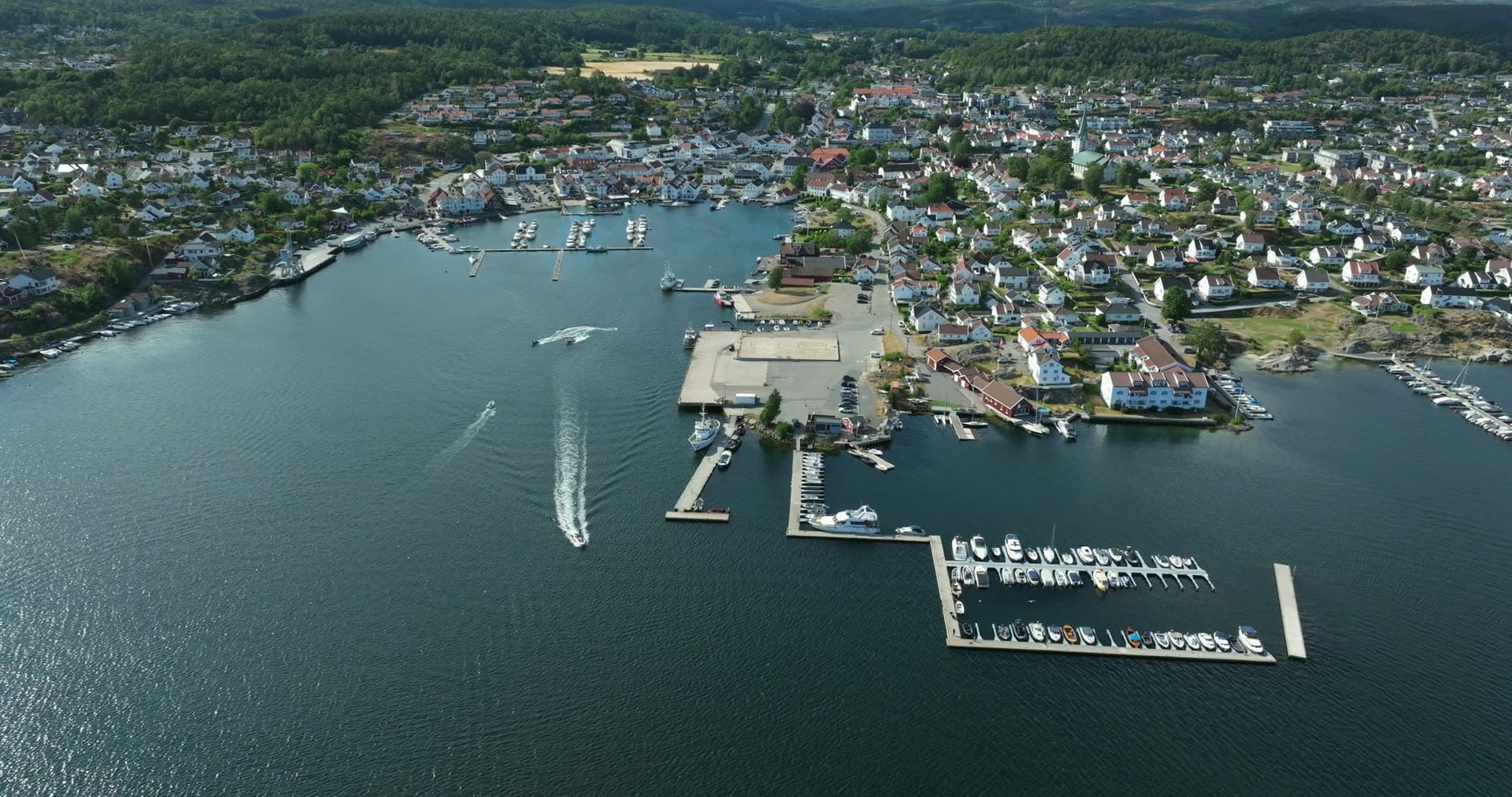 Speedboat wake past marina piers, Lillesand, Norway