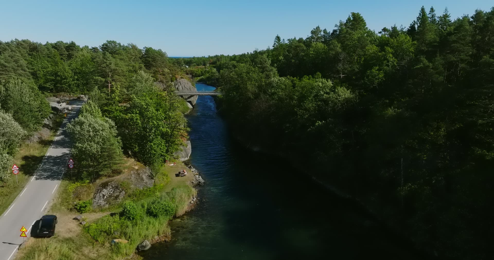 Arched bridge over the canal from the rocky bank, Lillesand, Norway