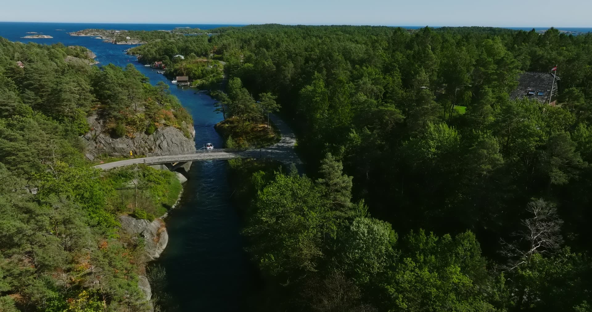 Walker crossing the bridge over the canal, Lillesand, Norway