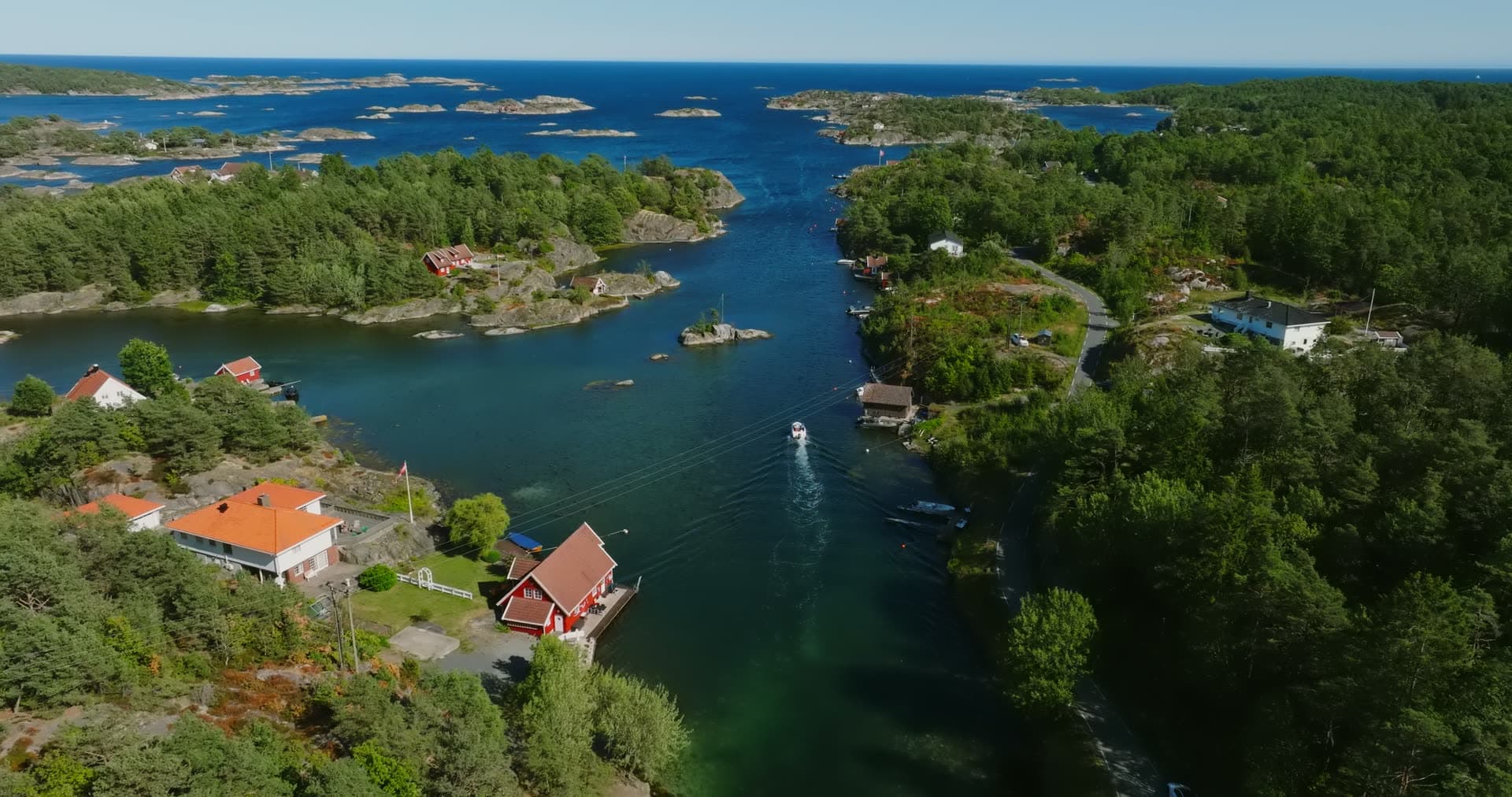 Red boathouse and tiled roofs by the sound, Lillesand, Norway
