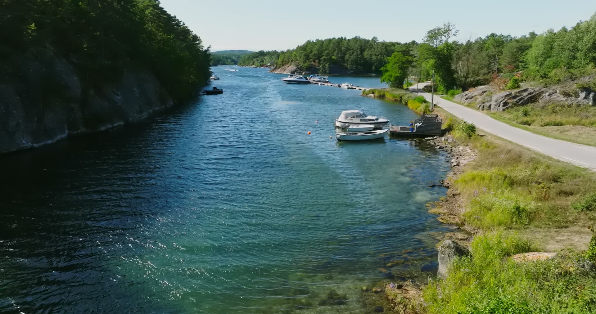 Low pass over the sound past moored boats, Lillesand, Norway