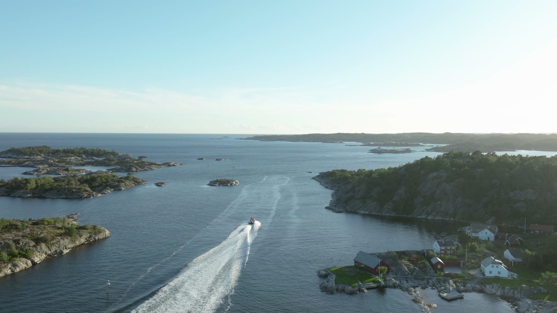 Speedboat wake between rocky islets, Lillesand, Norway