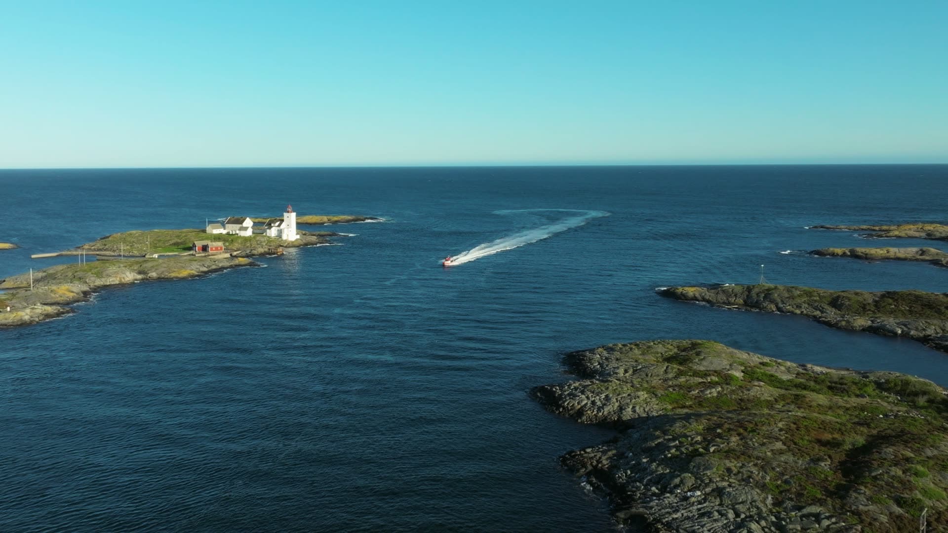 RIB wake past lighthouse islet and skerries, Lillesand, Norway