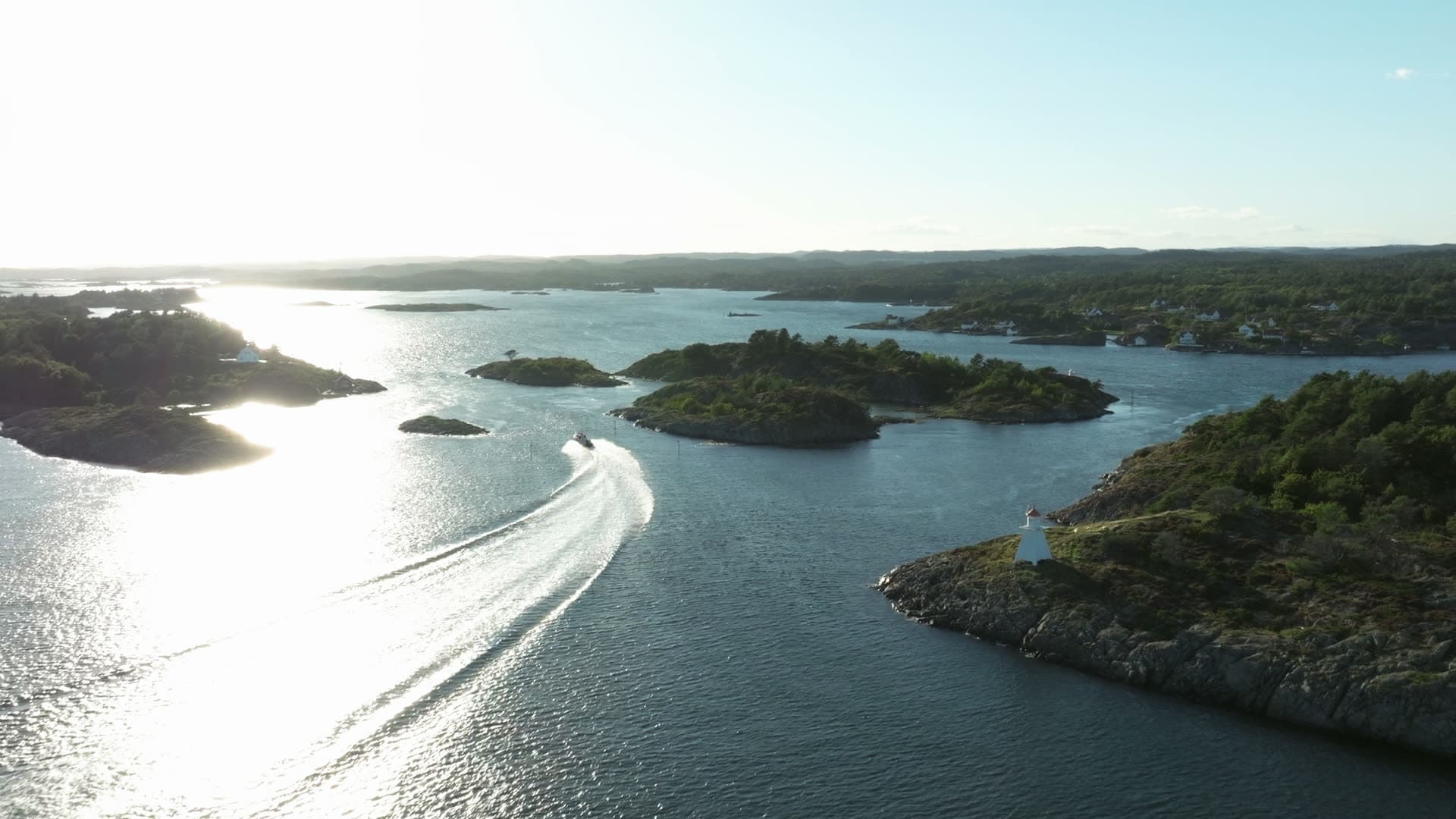 Speedboat wake past islets and beacon, Lillesand, Norway