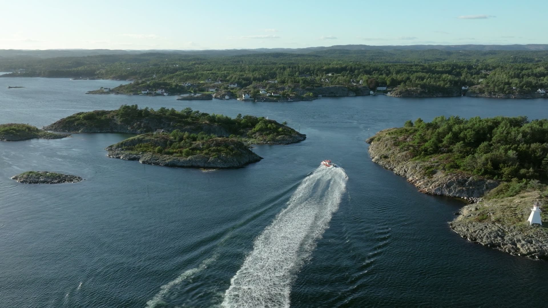 Speedboat wake between wooded islets, Lillesand, Norway