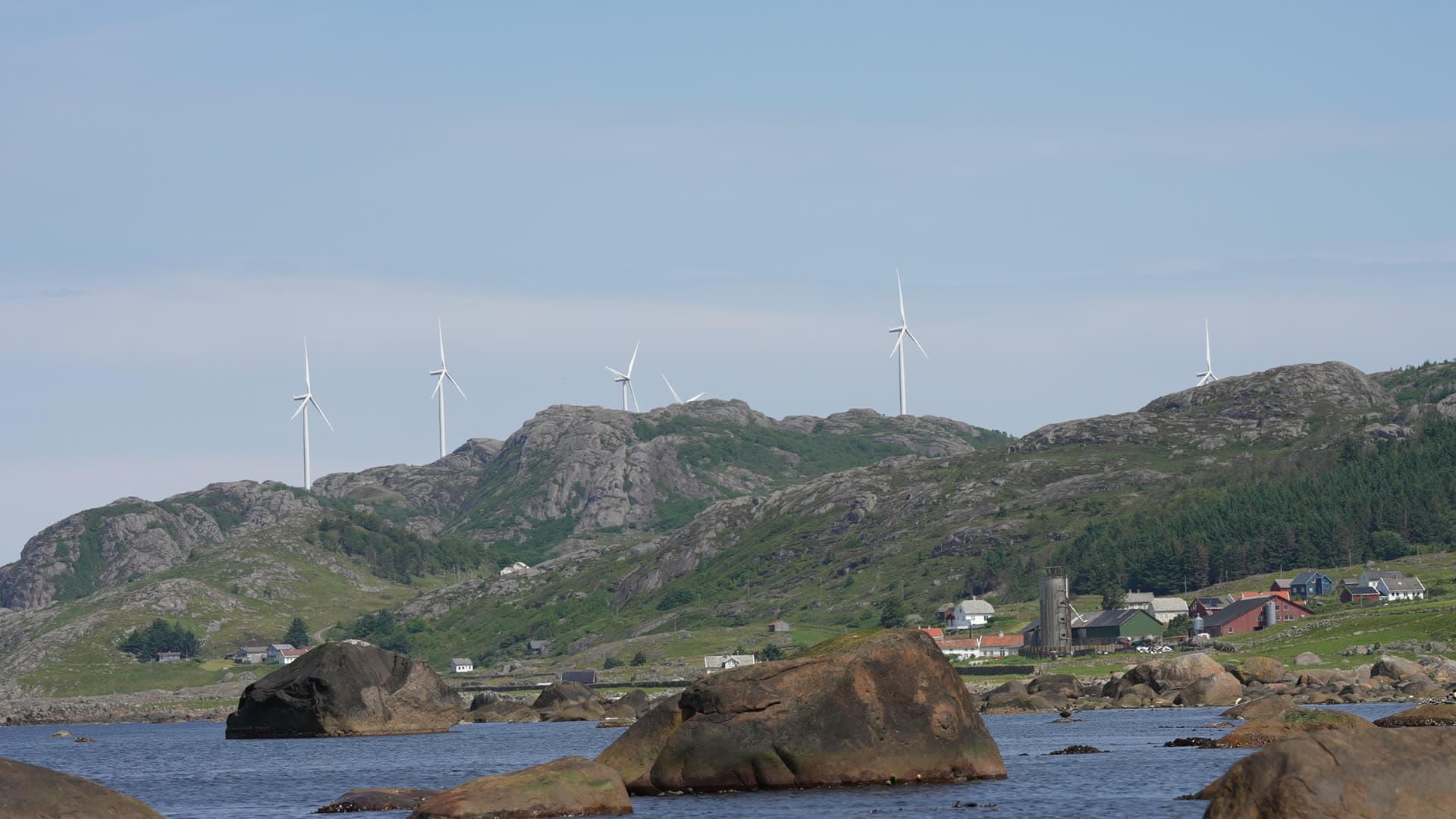 Wind turbines on ridge above boulder shore, Lista, Norway