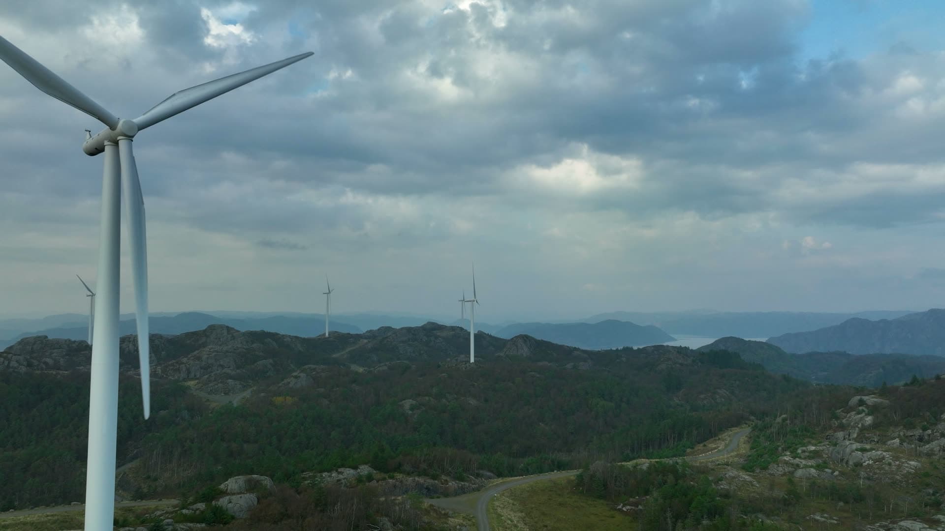 Passing wind turbine on rocky ridge, Lista, Norway