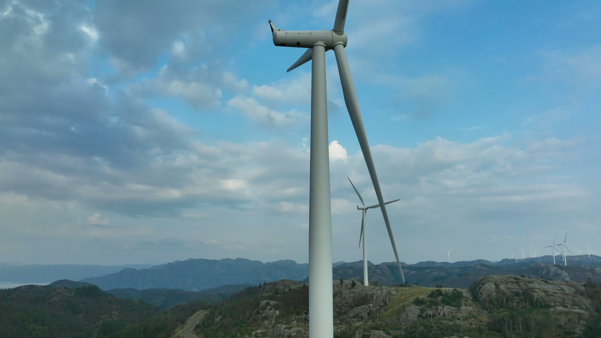 Rising past turbine tower on rocky ridge, Lista, Norway