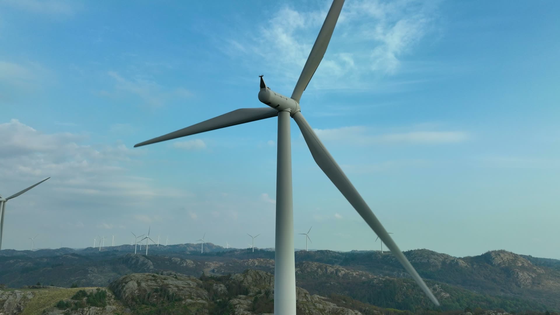 Close pass by turbine rotor over rocky hills, Lista, Norway