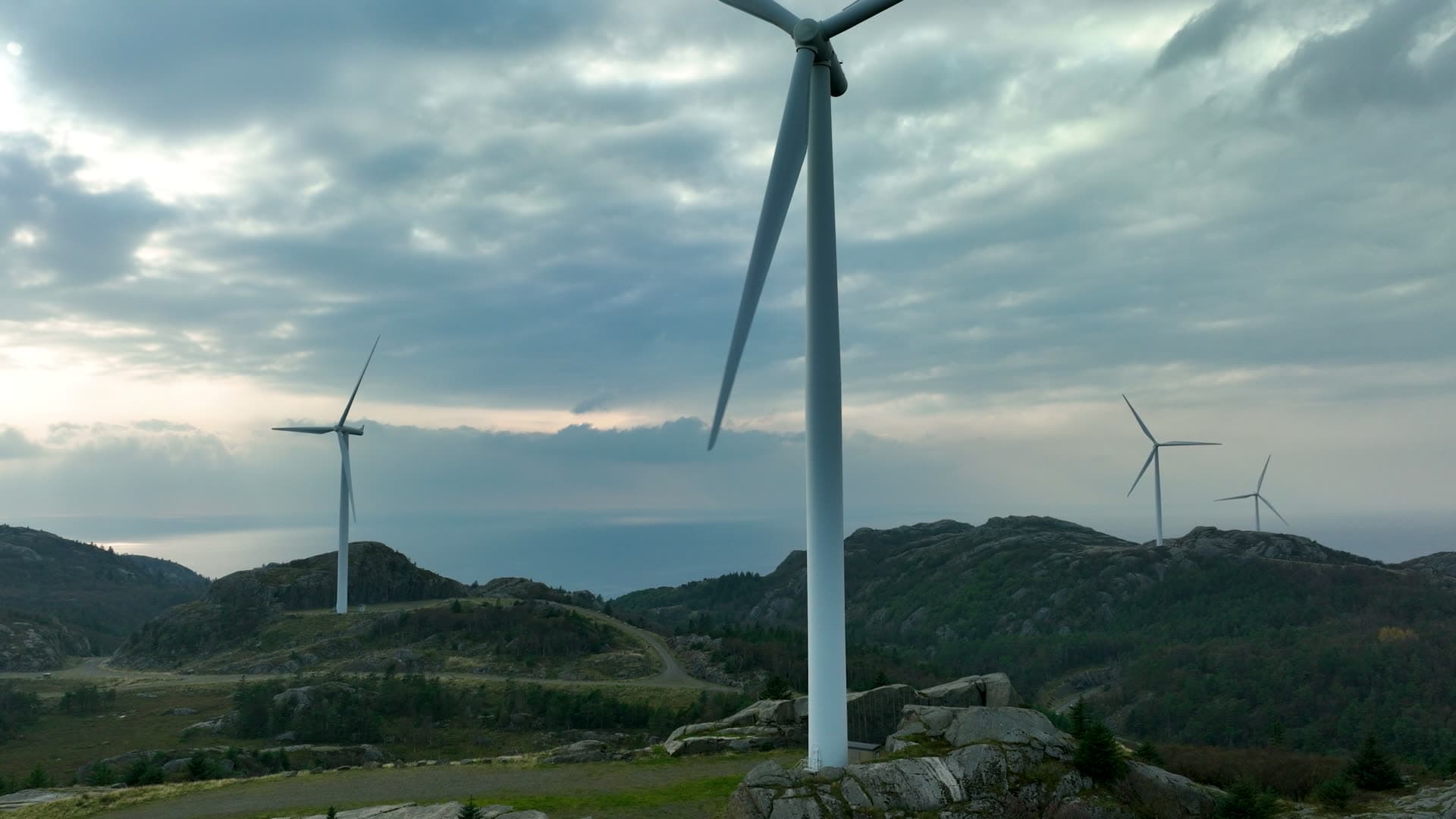 Rising past wind turbine on rocky ridge, Lista, Norway