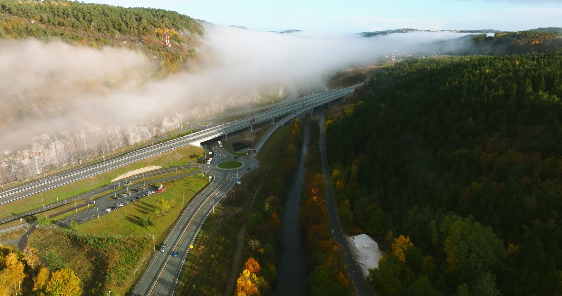 Fog rolling over highway bridge and roundabout, Monan, Norway