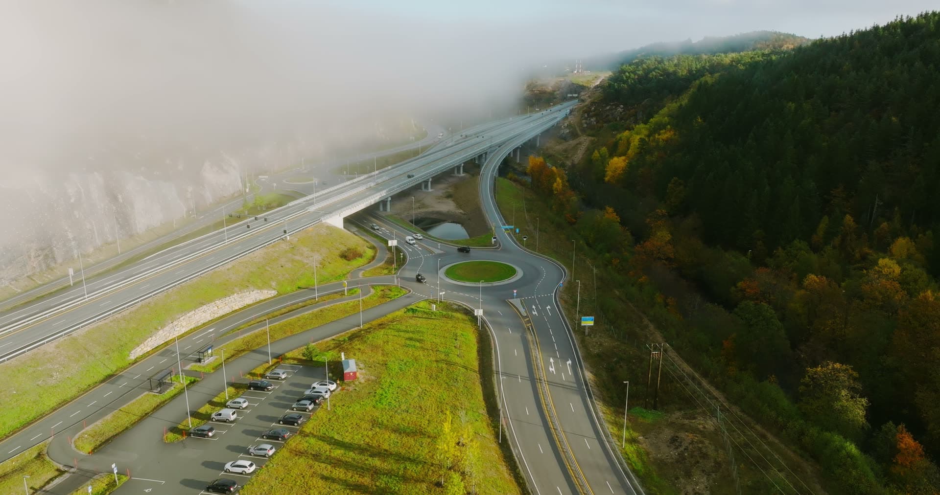 Fog drifting over roundabout and highway viaduct, Monan, Norway