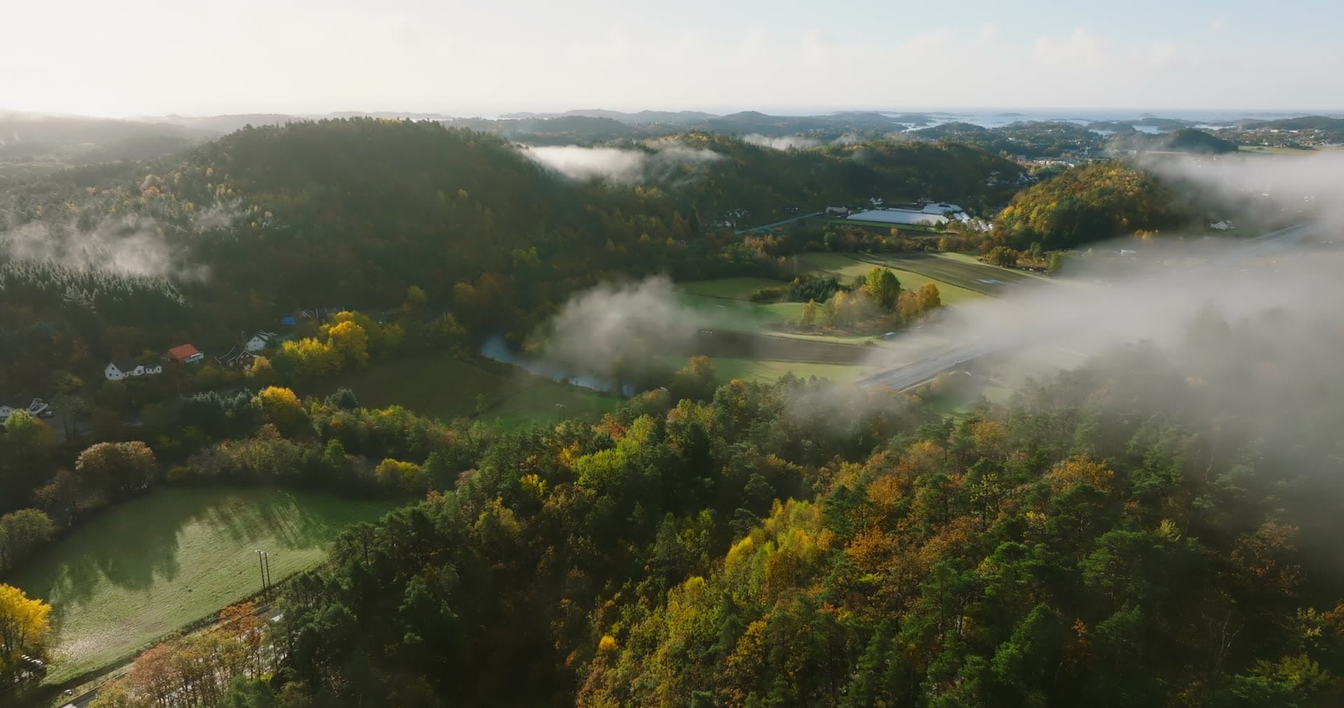 Low fog over highway through autumn farmland, Monan, Norway