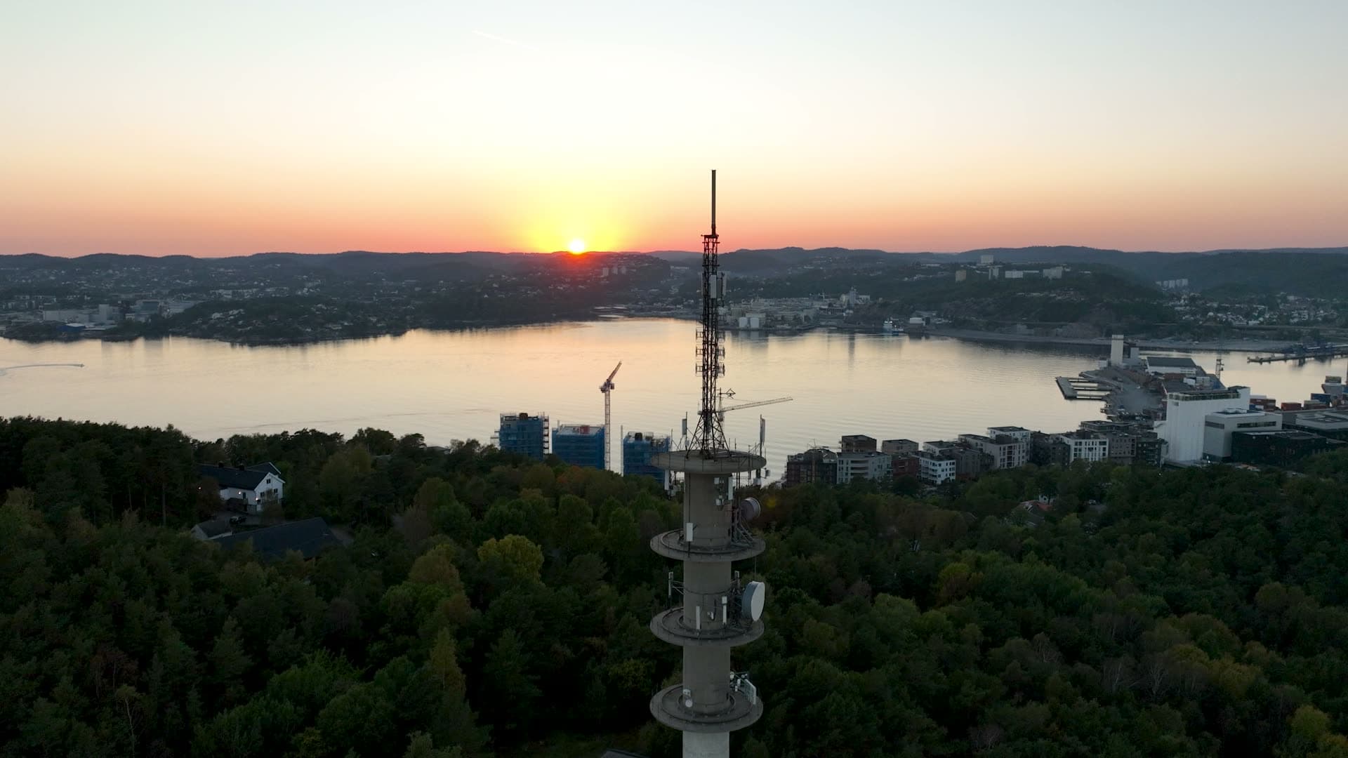 Telecom mast above forest at sunset, Odderøya, Norway