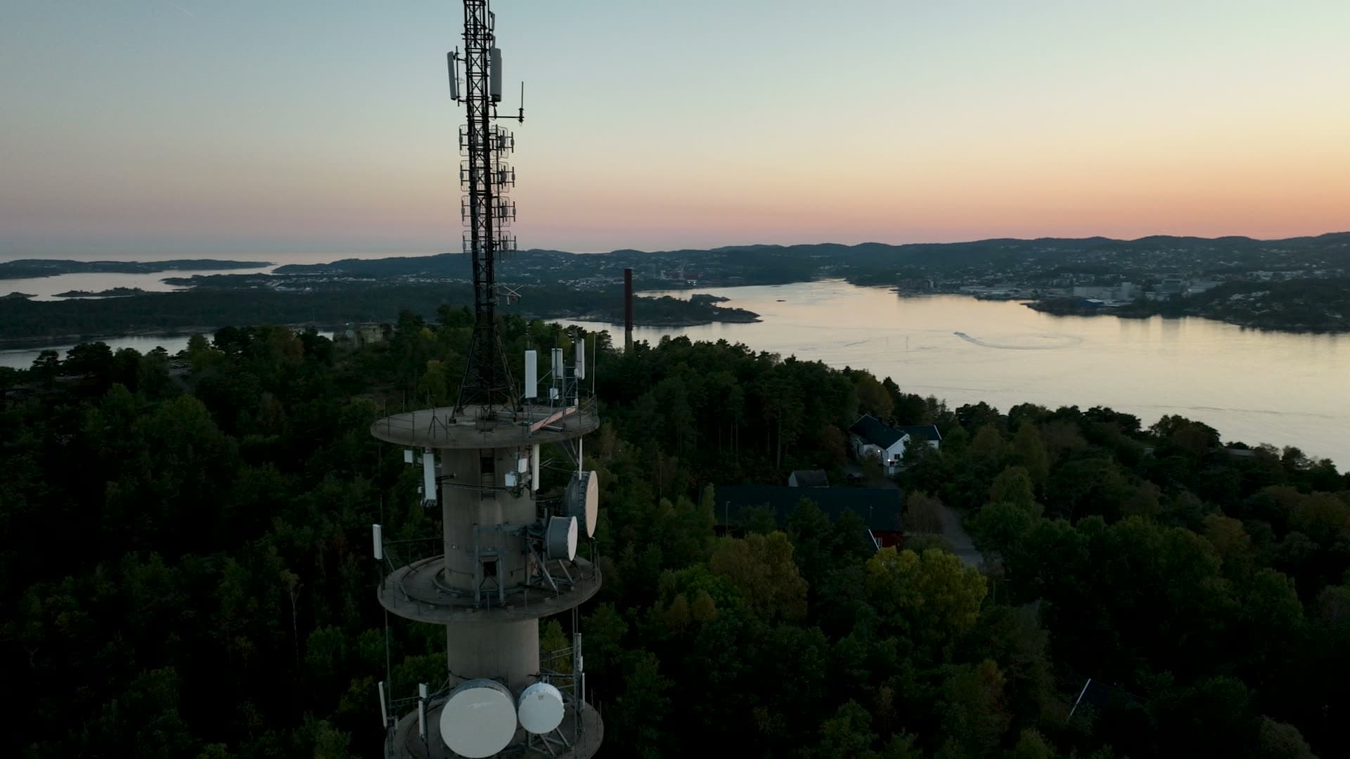 Orbit around telecom mast above forest, Odderøya, Norway