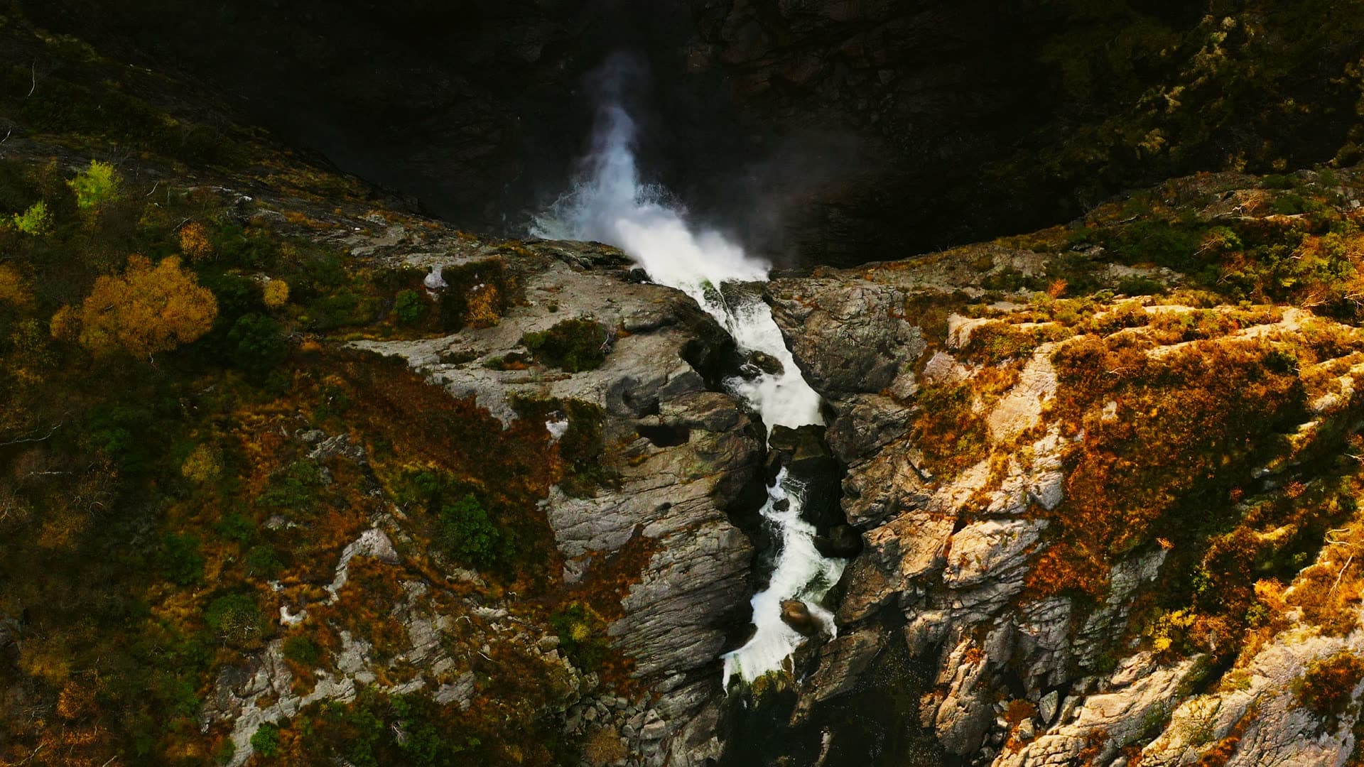 Waterfall spilling into rocky autumn gorge, Månafossen, Norway