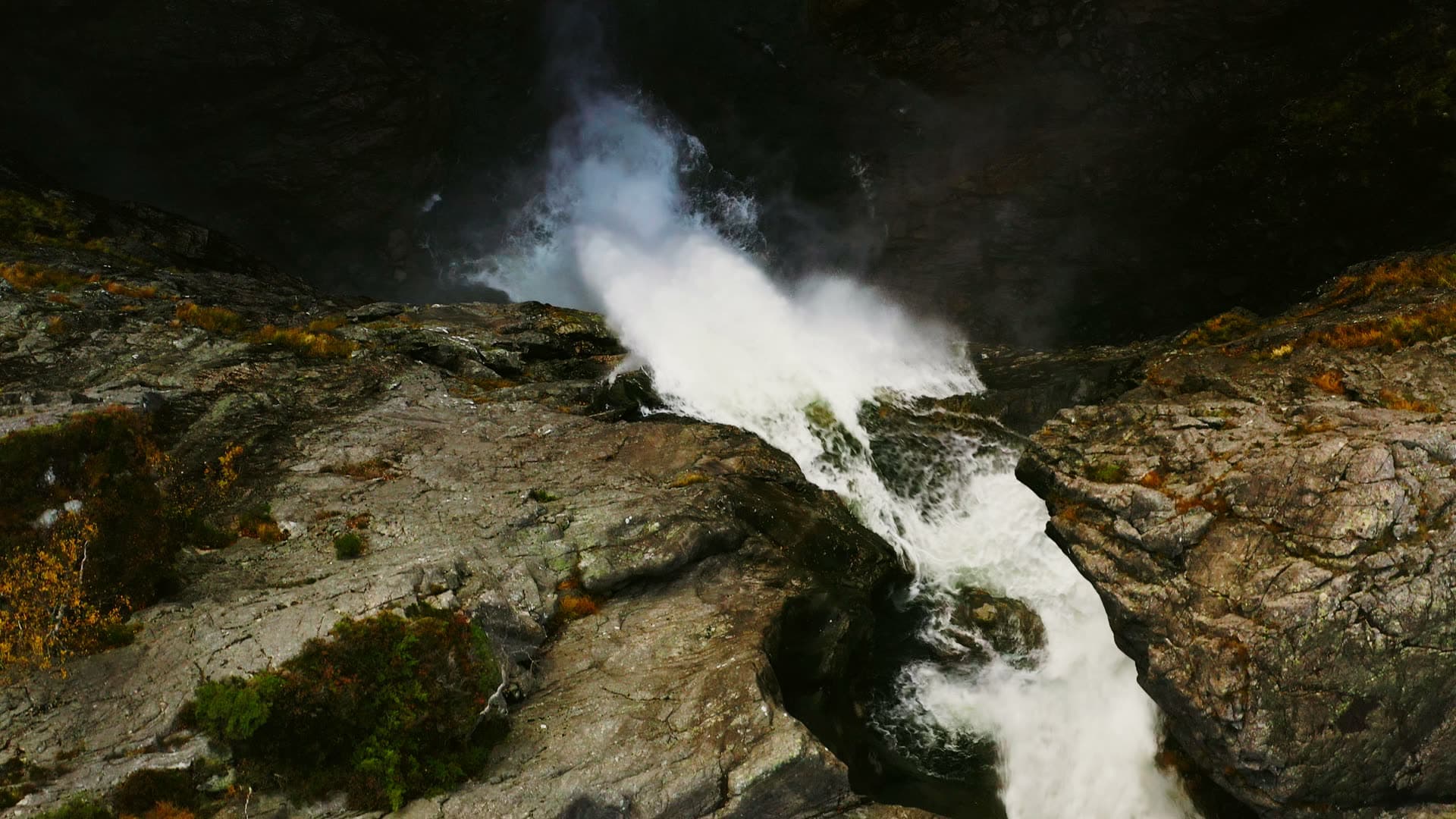 Waterfall spray rising off bare rock lip, Månafossen, Norway