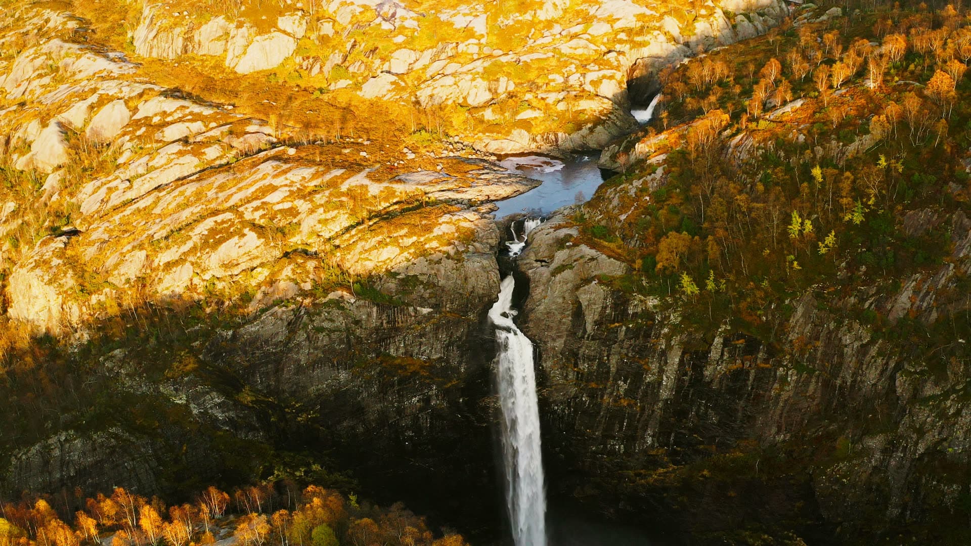 Waterfall dropping from bare rock plateau, Månafossen, Norway